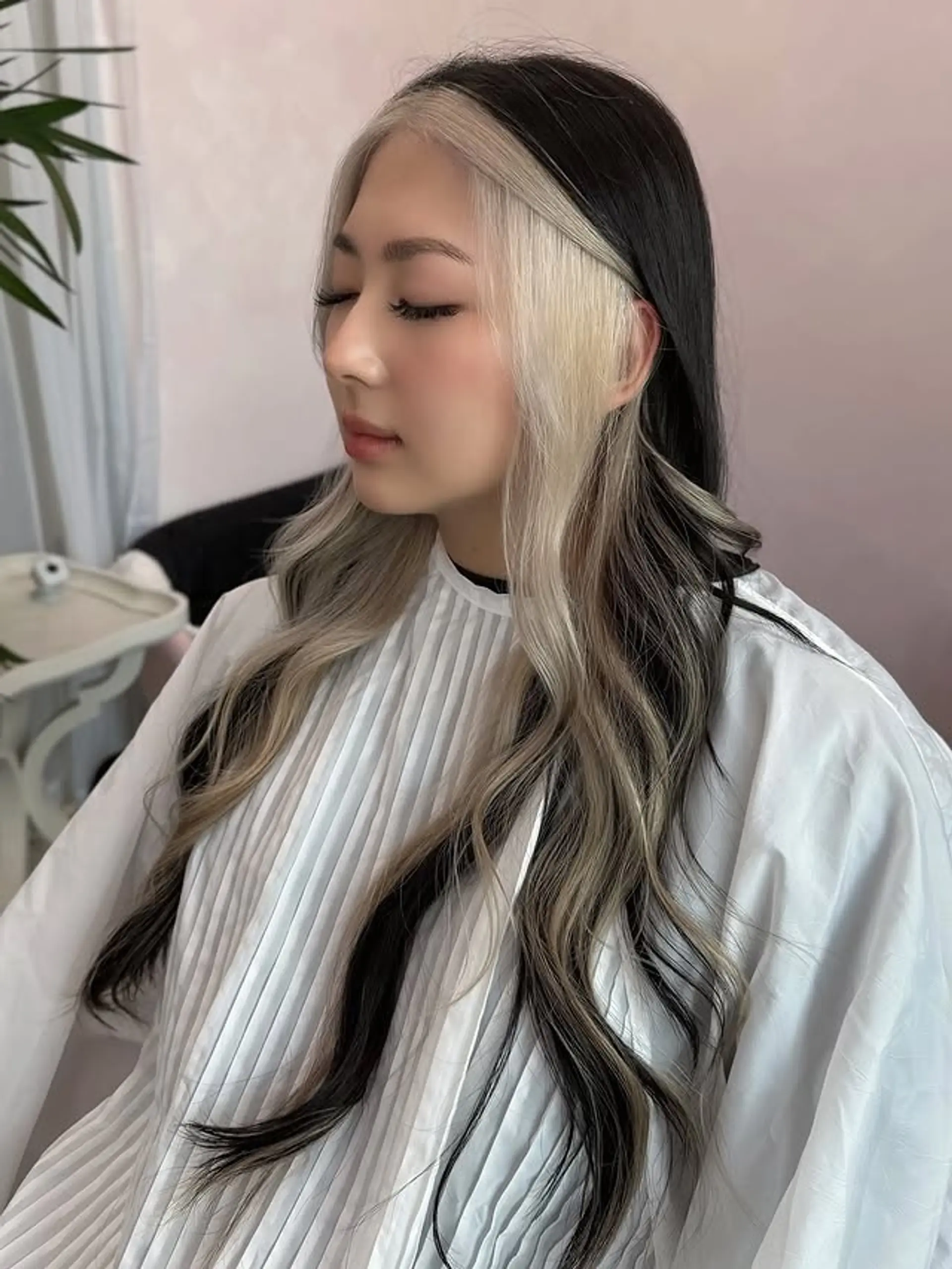Long, wavy hair with a dramatic two-tone effect, showcasing prominent platinum blonde face-framing sections that starkly contrast with the dark black base color, creating a modern and edgy look. 1