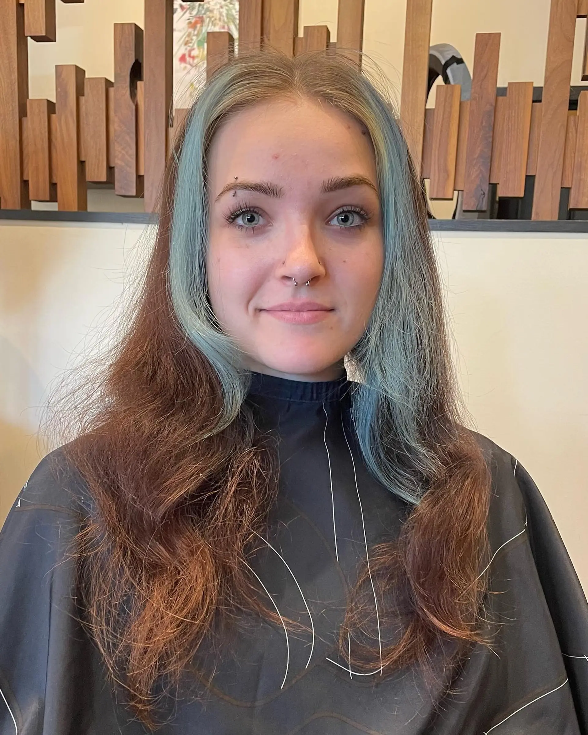 A modern take on the classic mullet, featuring layered, face-framing teal and blonde highlights. 2