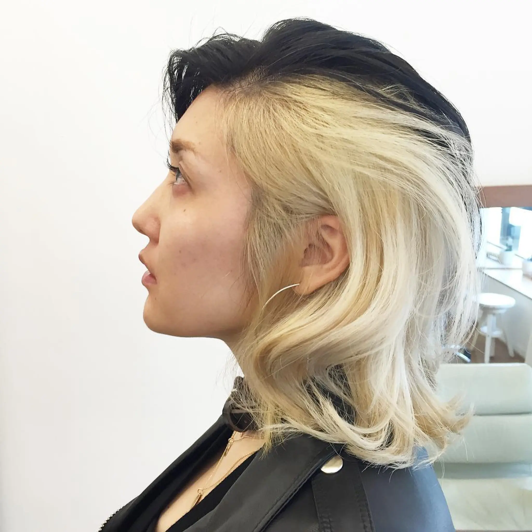 A striking two-toned look, divided in the middle with one side bleach blonde and the other dark black. It features a side part, voluminous soft waves, and a medium length with layered cuts. by @th5mayu