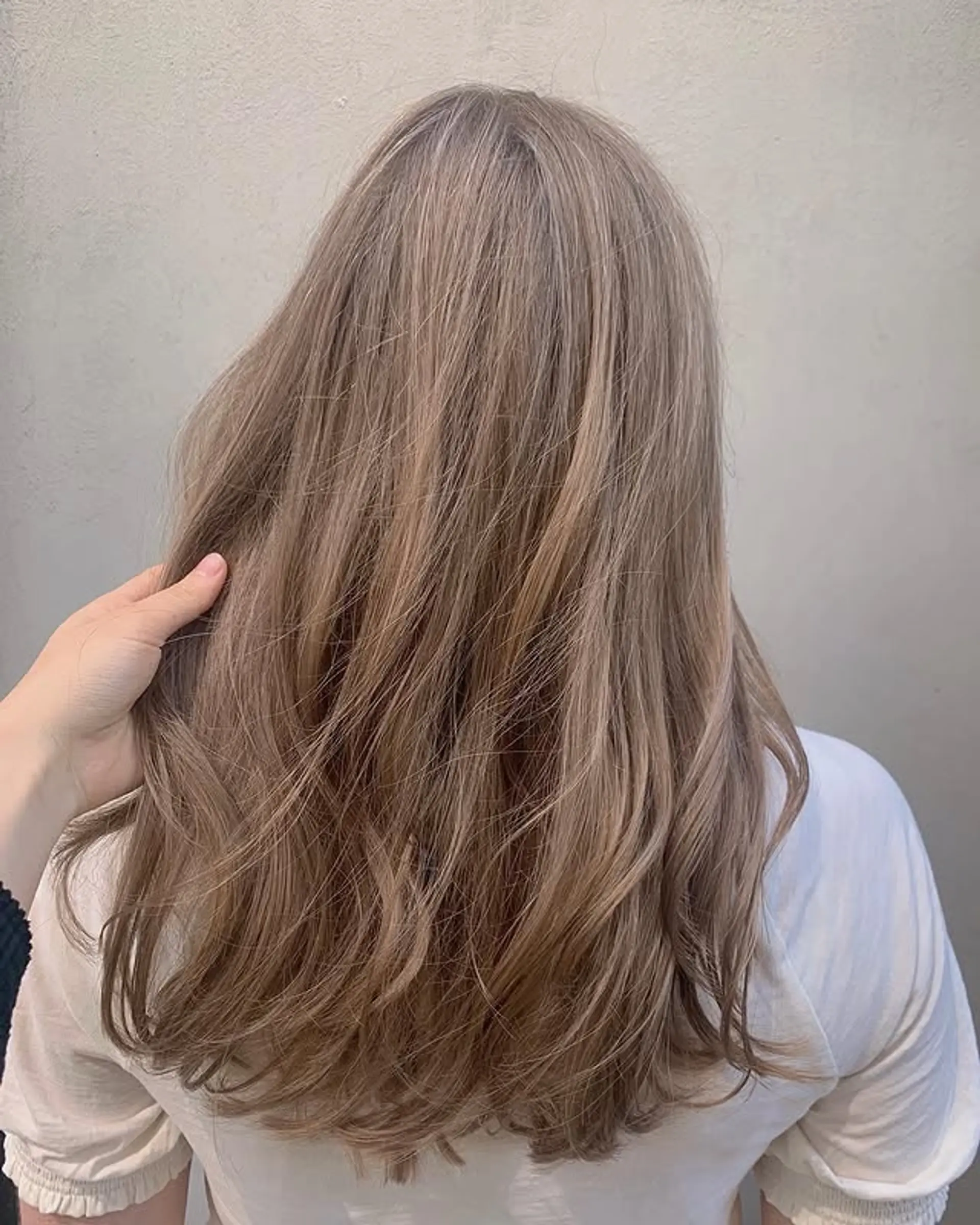 A long, wavy ash blonde balayage with soft layers and a natural, low-maintenance look. 1
