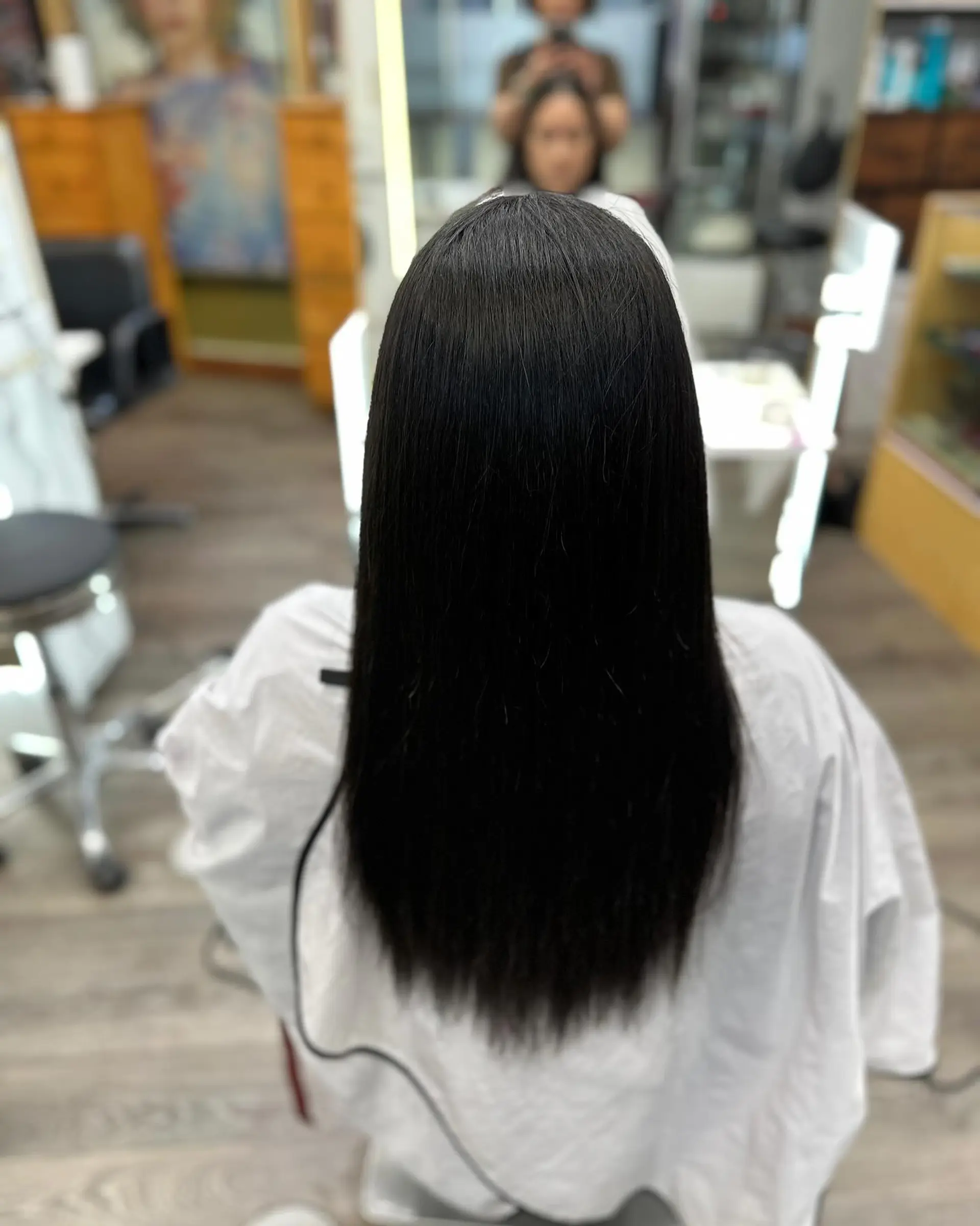 Glossy, pin-straight long black hair styled smooth and sleek down the back. 1
