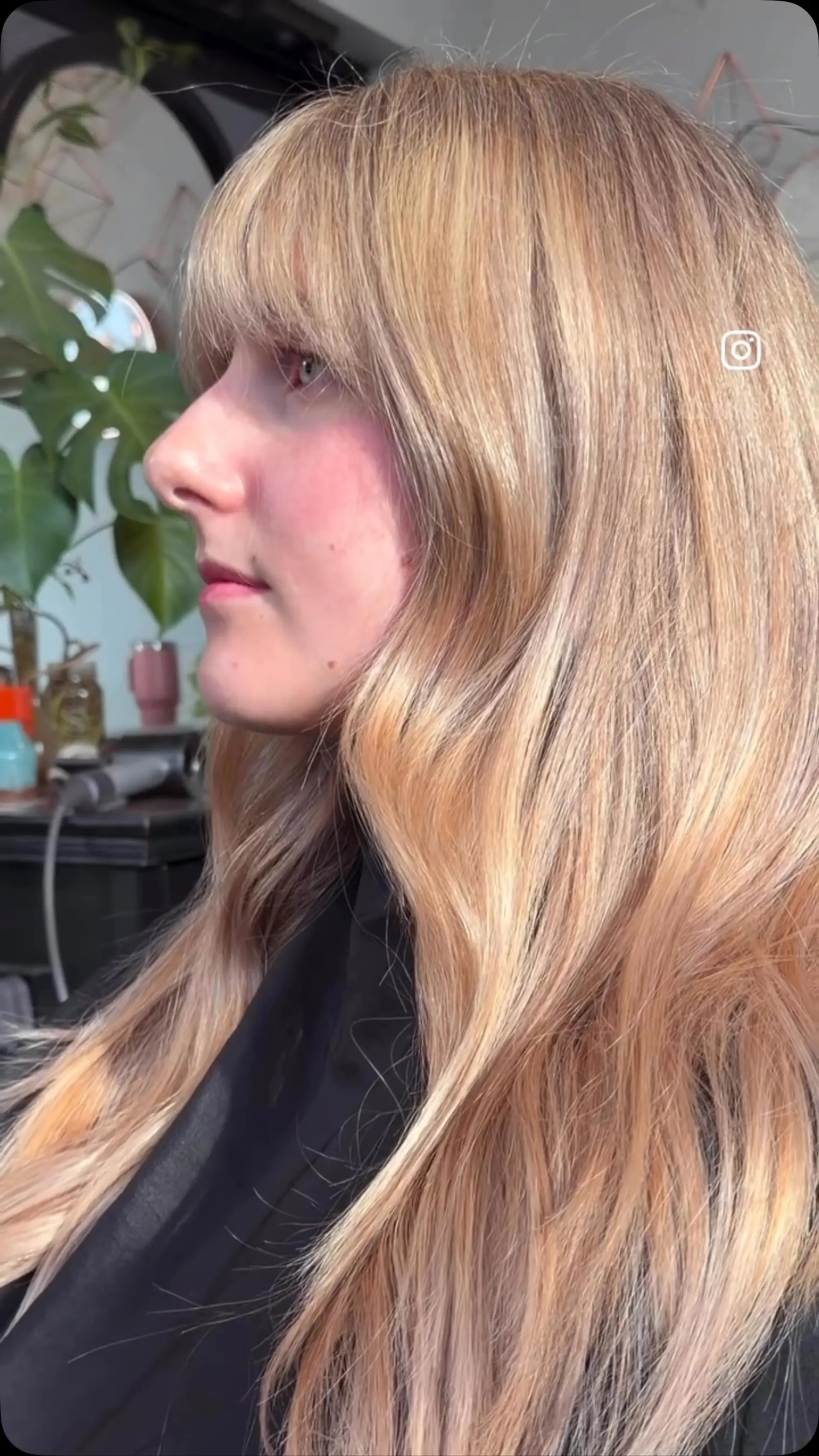 Long golden blonde hair cut with straight textured bangs and soft face-framing waves. 1