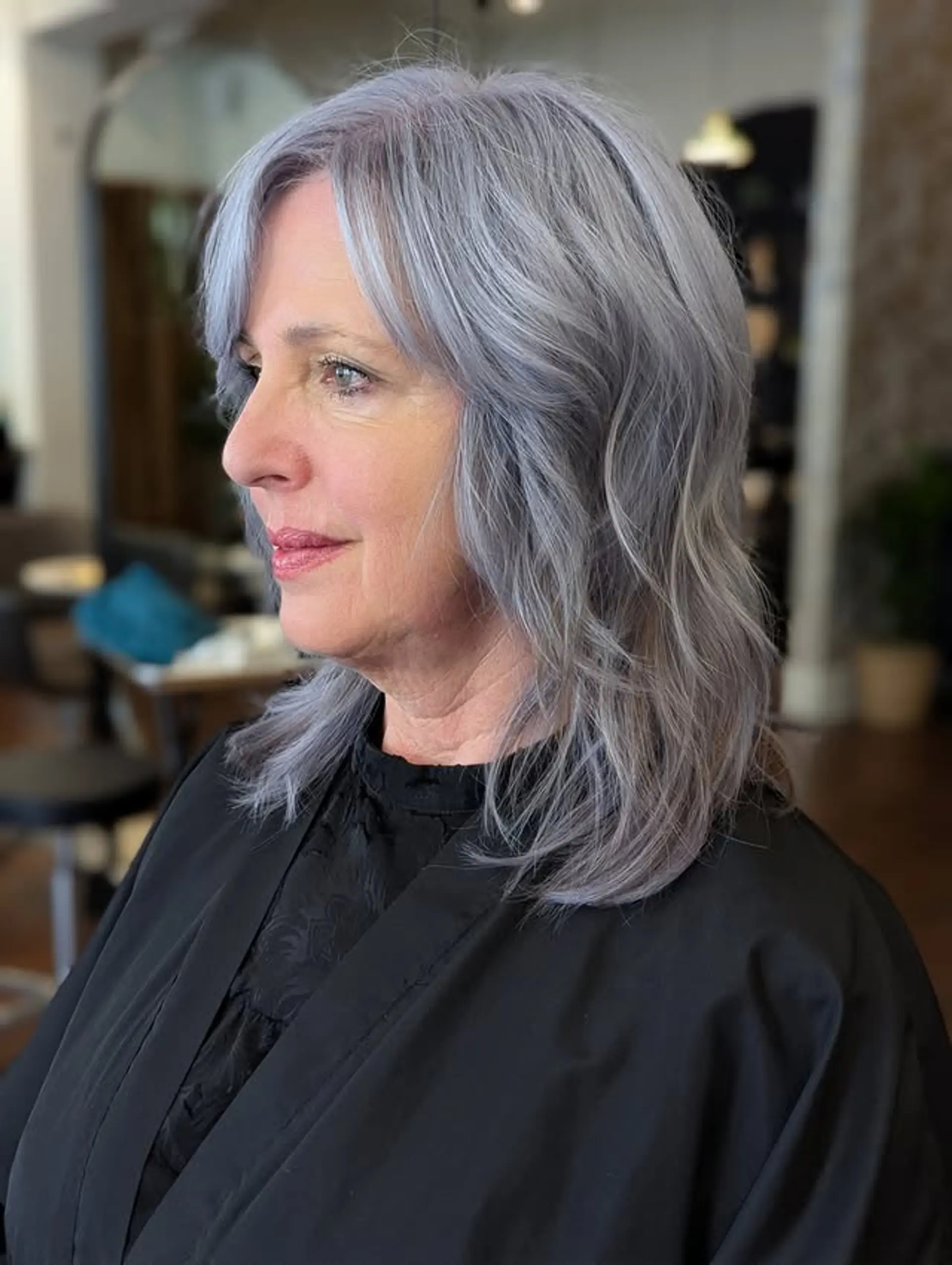 A layered shoulder-length haircut with side bangs, perfect for wavy hair. 1