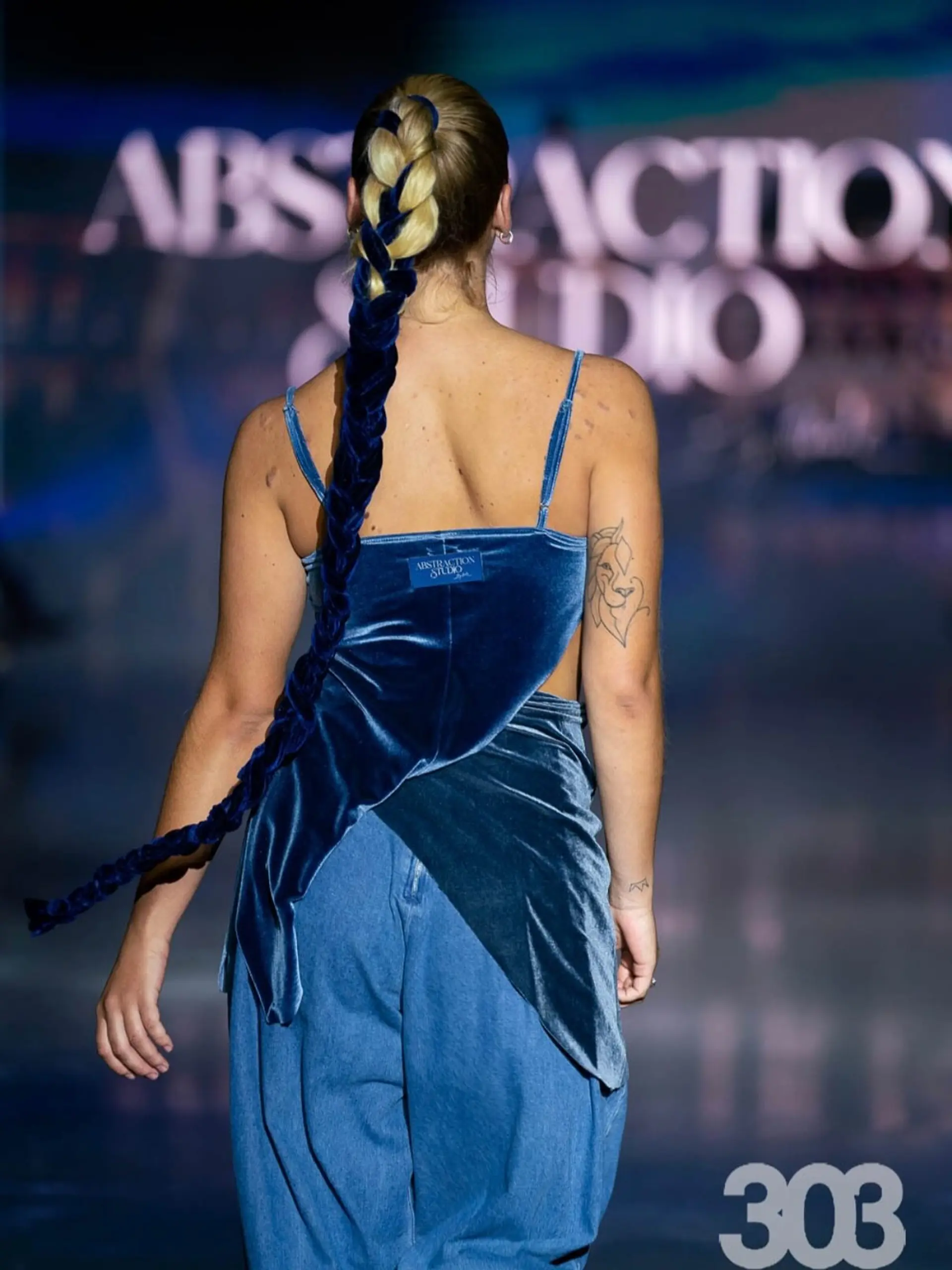 A sleek ponytail styled into an extended braid seamlessly interwoven with rich blue velvet ribbon. 1