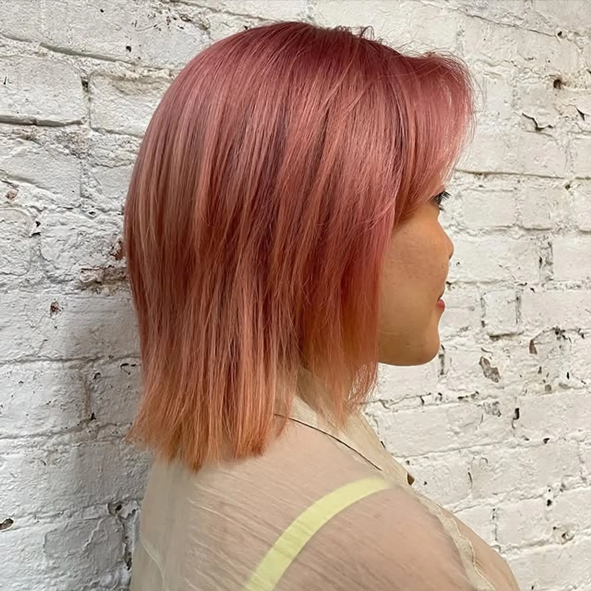 A stylish and contemporary bob with face-framing bangs and a rose gold color melt. 1