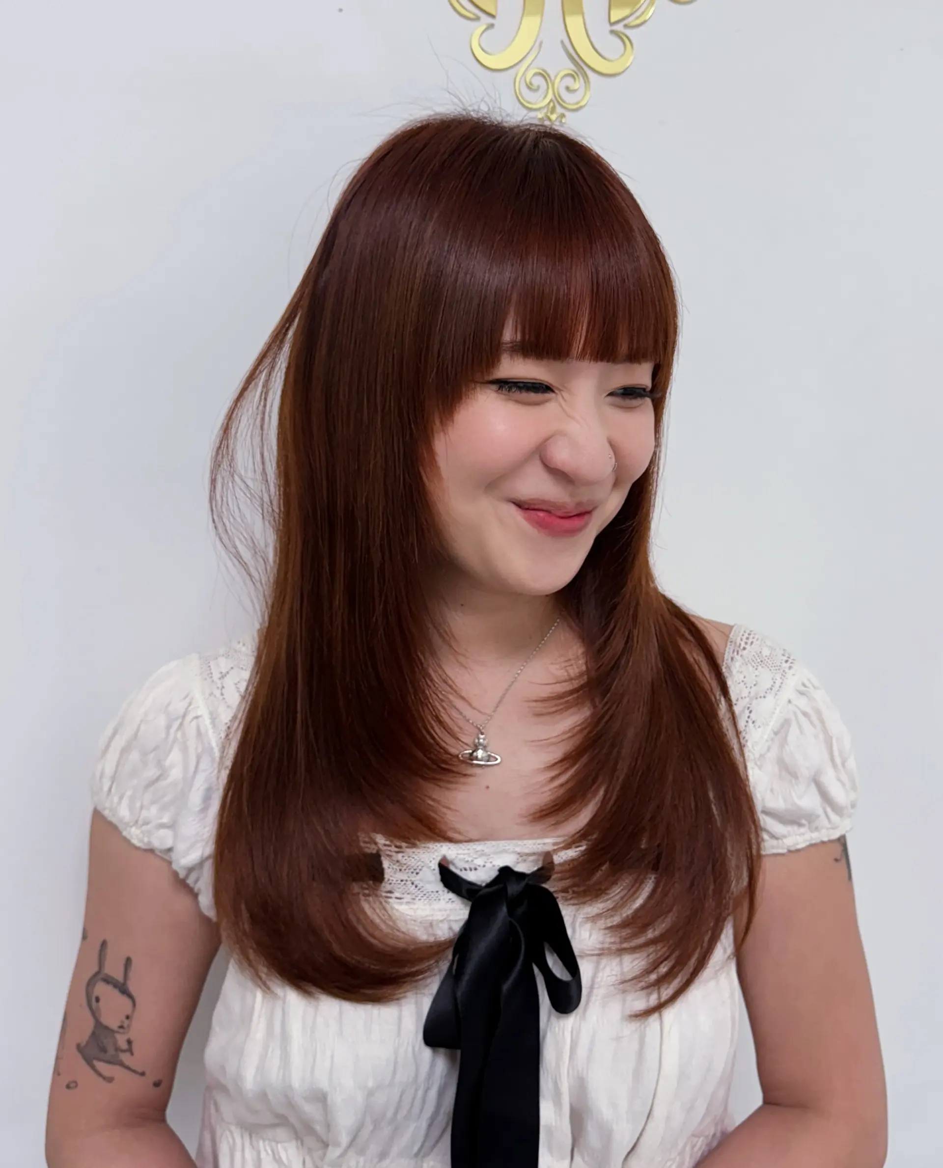 A chic layered hairstyle with face-framing curtain bangs and a smooth, straight finish. 1