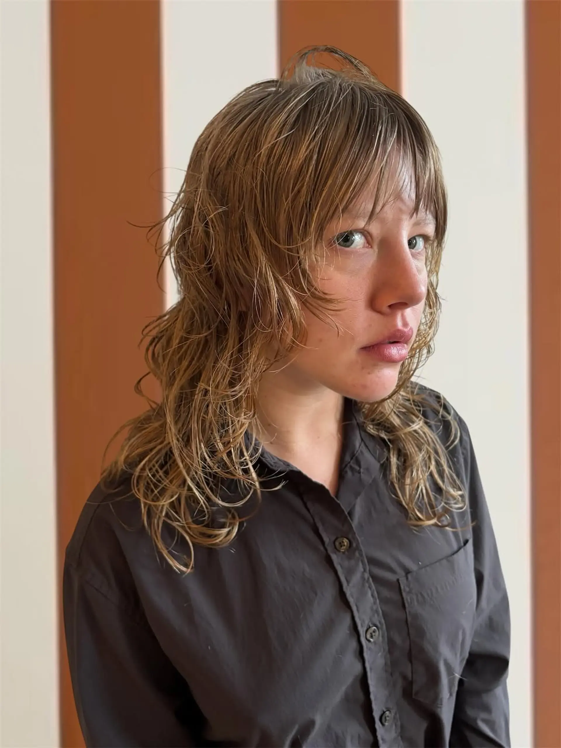 A choppy, medium-length layered haircut featuring a shaggy, undone texture and wispy forehead-grazing bangs. 1