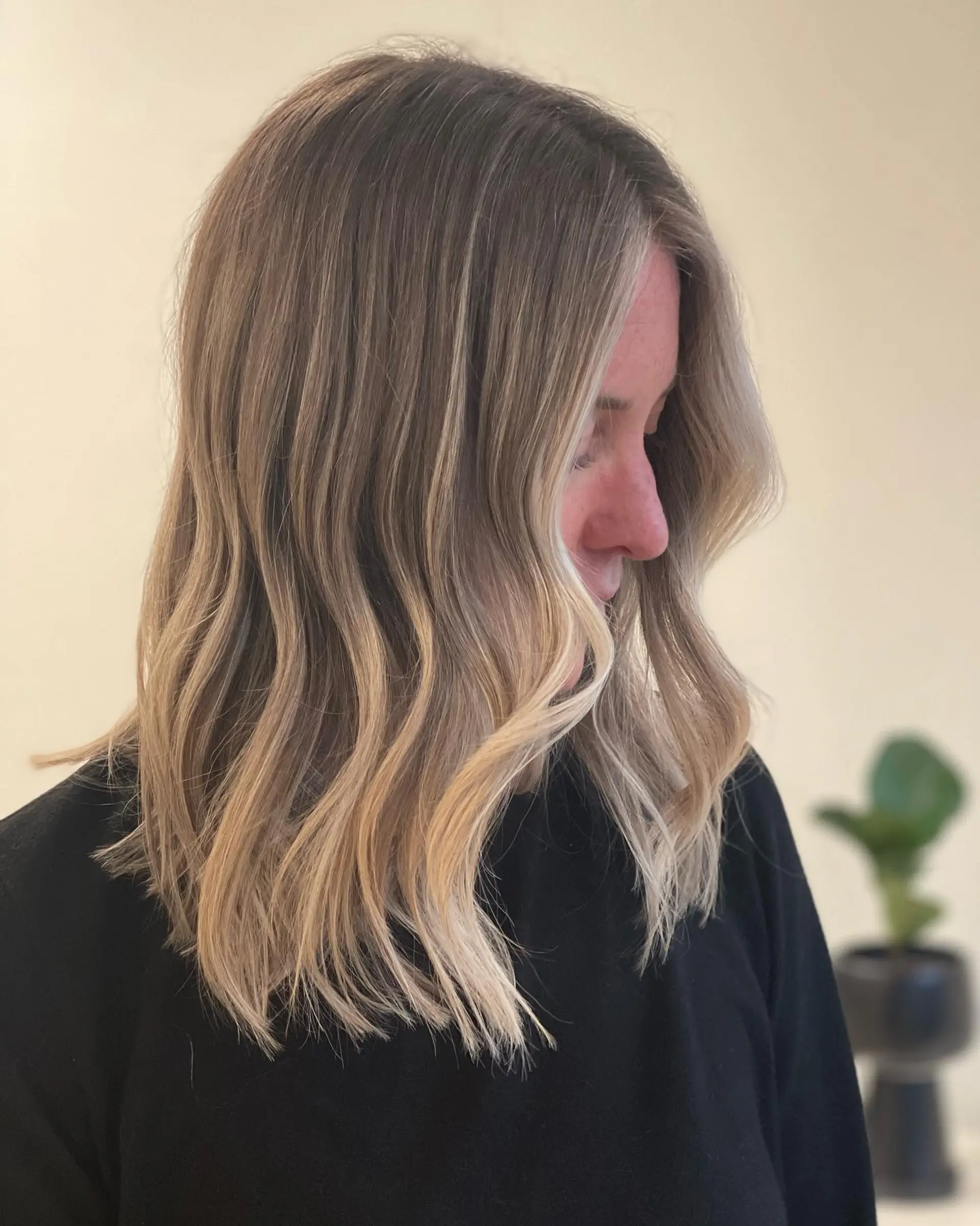 Medium-length textured lob styled in soft, relaxed waves with a seamless, lived-in dimensional blonde color. 1