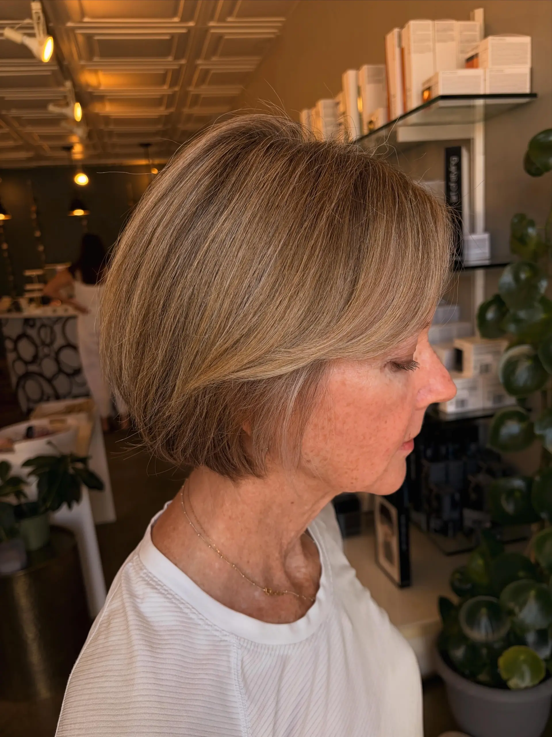 A sleek, chin-length bob featuring soft blended blonde highlights and a smooth, rounded finish. 1