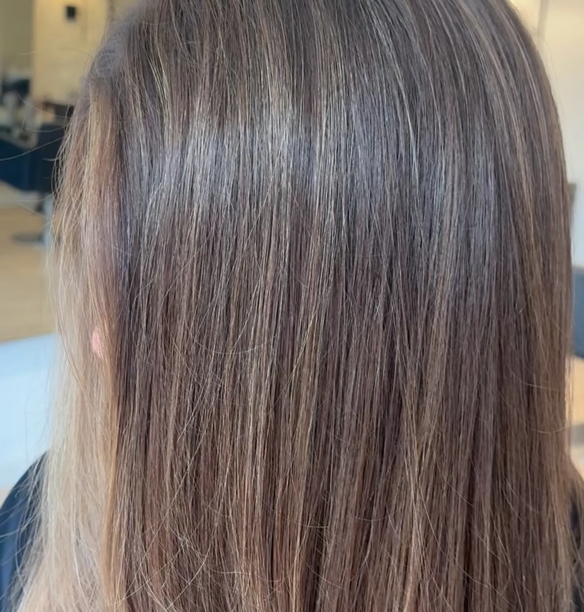 A glossy dimensional brunette hairstyle featuring finely blended highlights throughout straight, smooth hair. 1