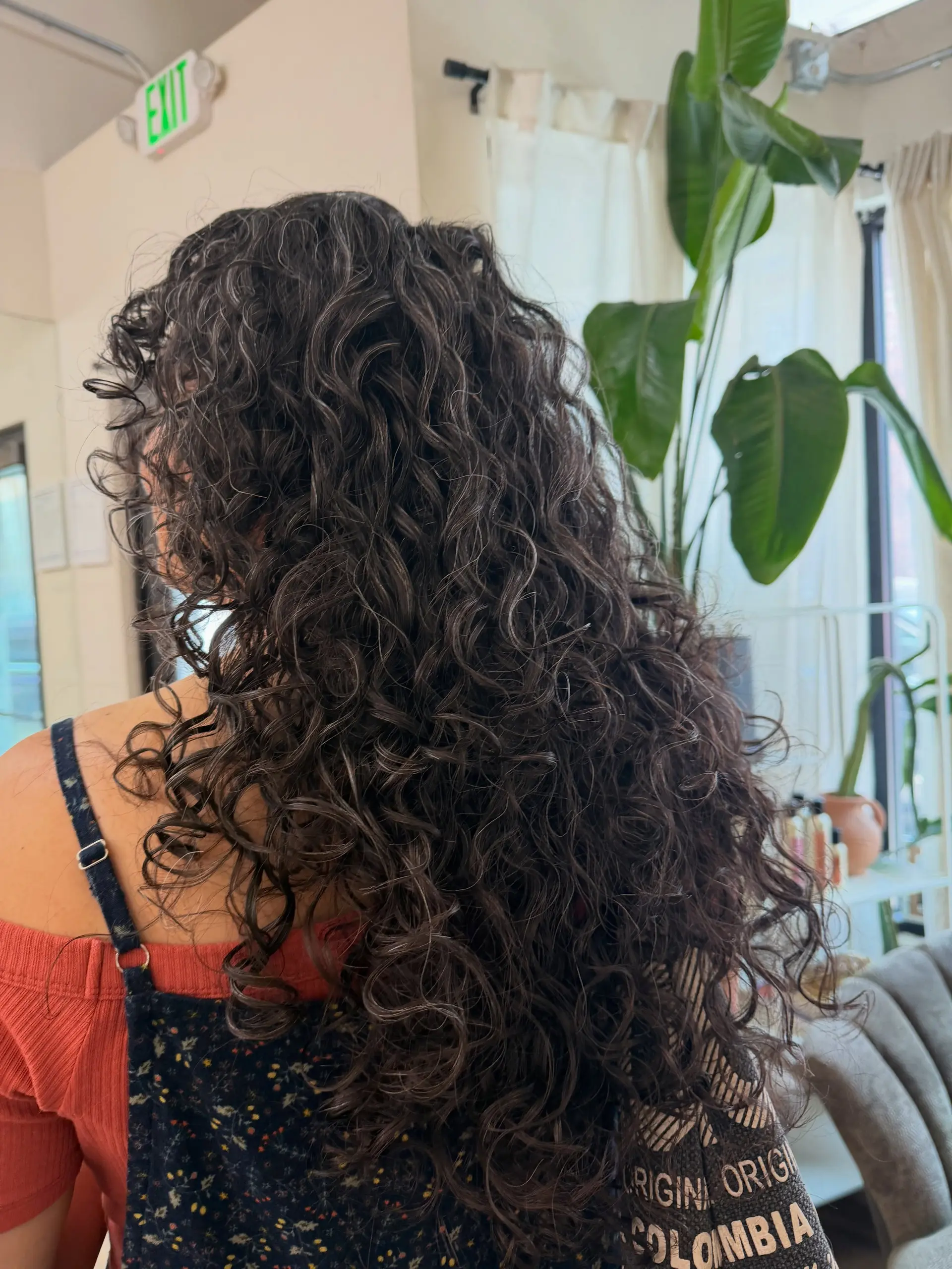 Cascading long curly hair cut with shape and layers for defined, bouncy ringlets. 1