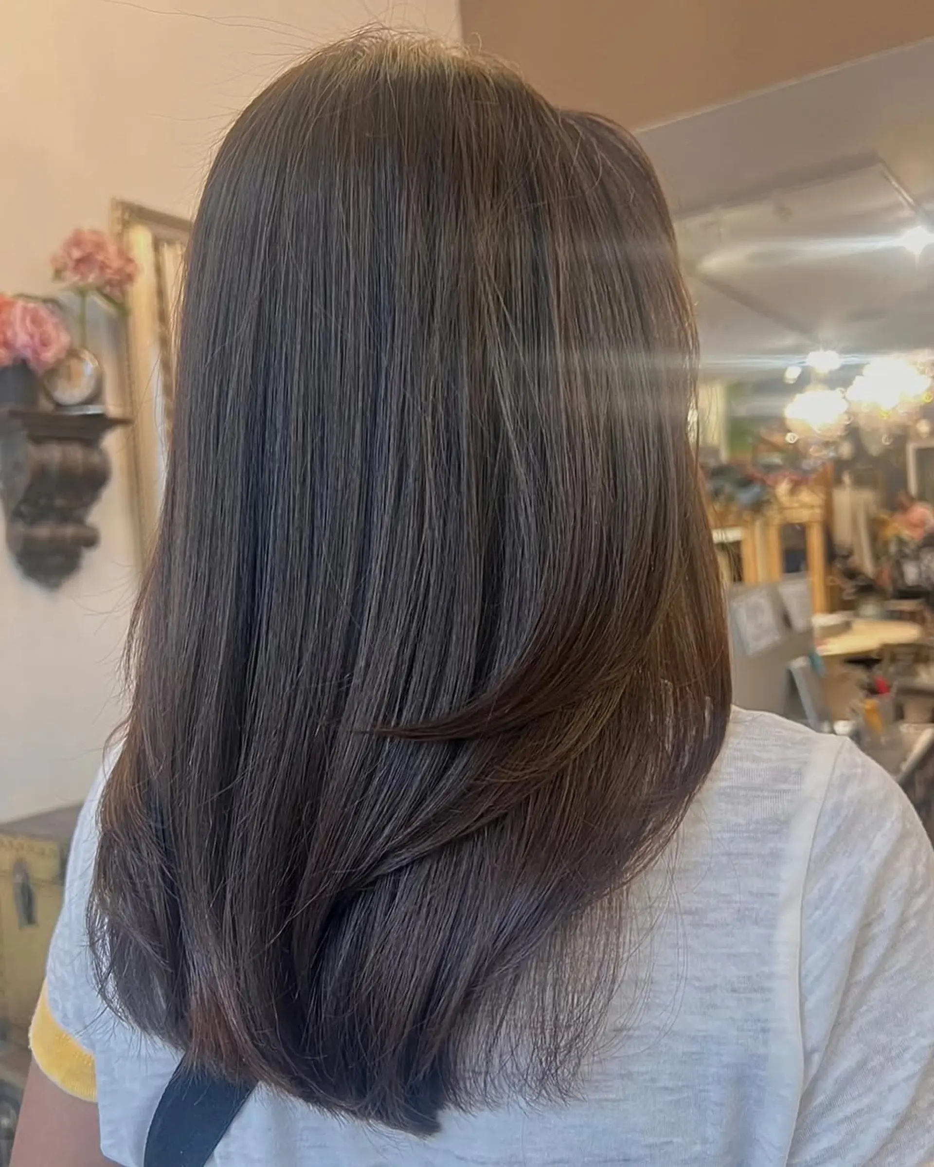 Long, straight, dark brown hair with smooth layers and a sleek, naturally shiny finish. 2