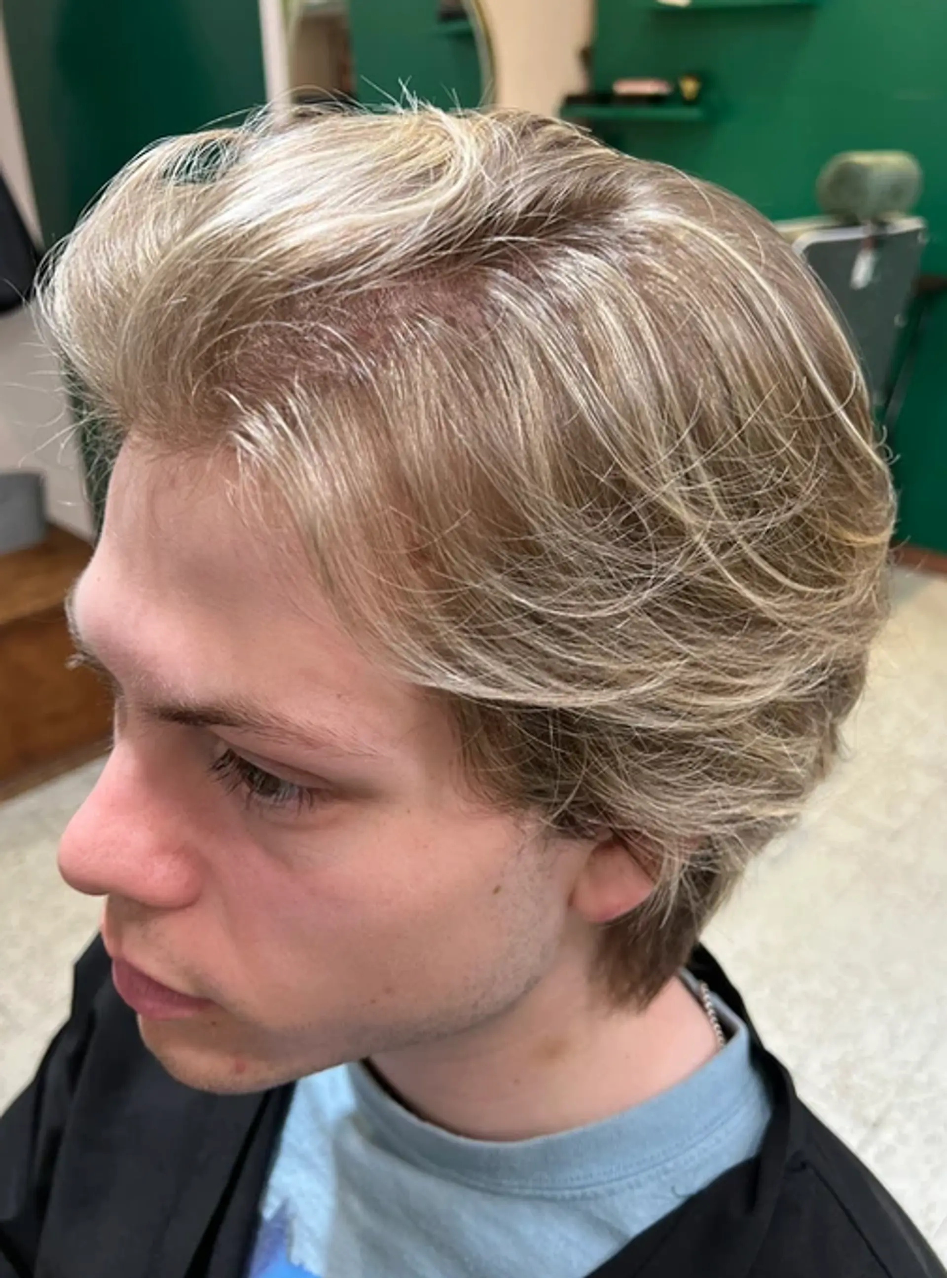 A medium-length wavy hairstyle with side-swept layers and natural volume, highlighted by a blonde color creating a soft, casual look. 1