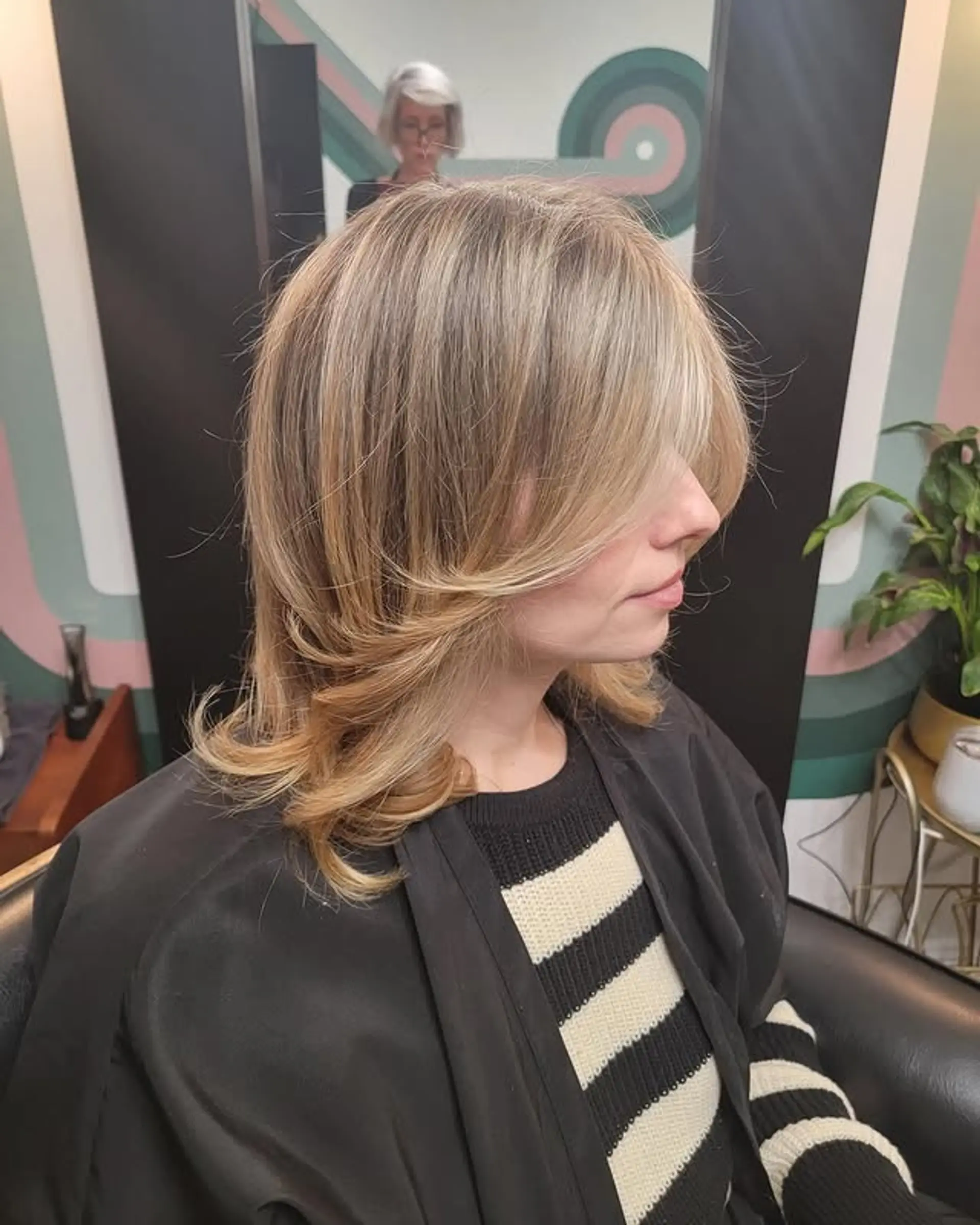 A trendy medium-length butterfly shag haircut with voluminous, face-framing layers and long curtain bangs, styled with soft, wavy ends that flick outward. 1