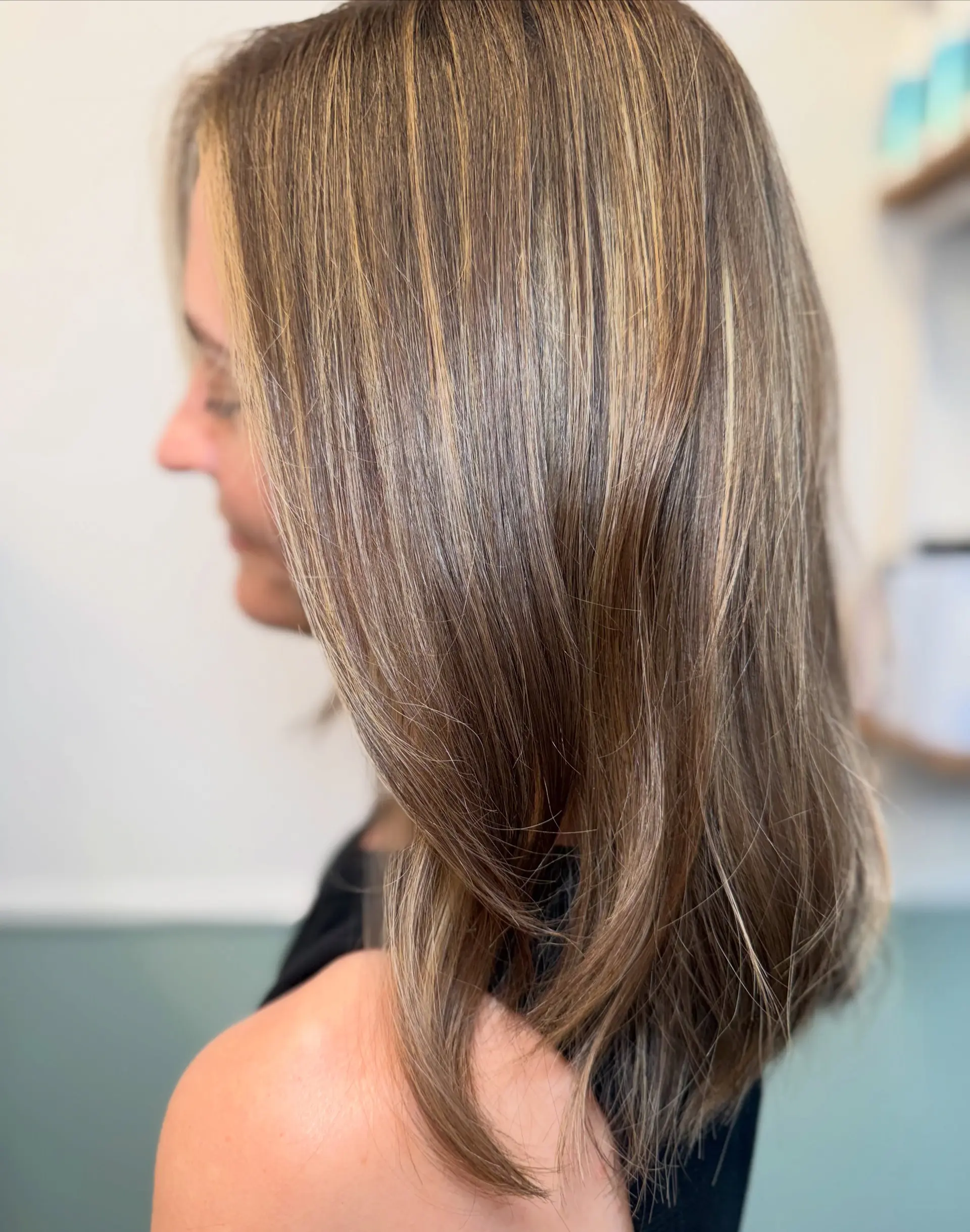 A sleek shoulder-length long bob featuring multi-dimensional honey blonde balayage over a soft brunette base. 1