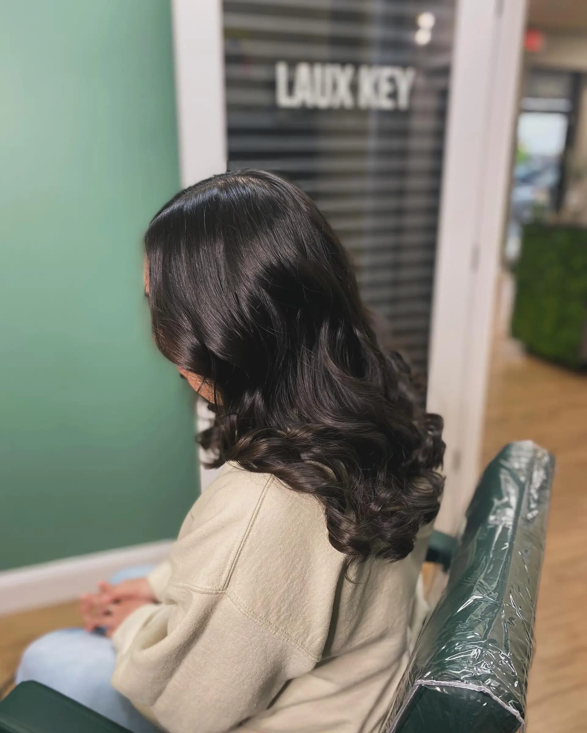 Smooth, glossy silk press styled with voluminous curls concentrated through the mid-lengths and ends. 1
