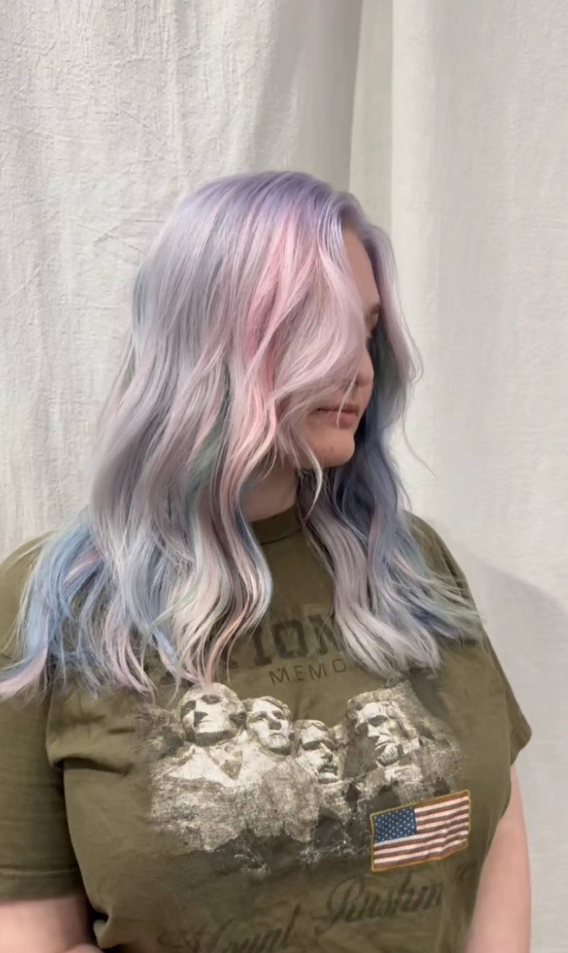 Long, wavy hair colored in pastel pink, lavender, and baby blue, featuring soft waves and a side-swept style for a voluminous and dreamy look. 1
