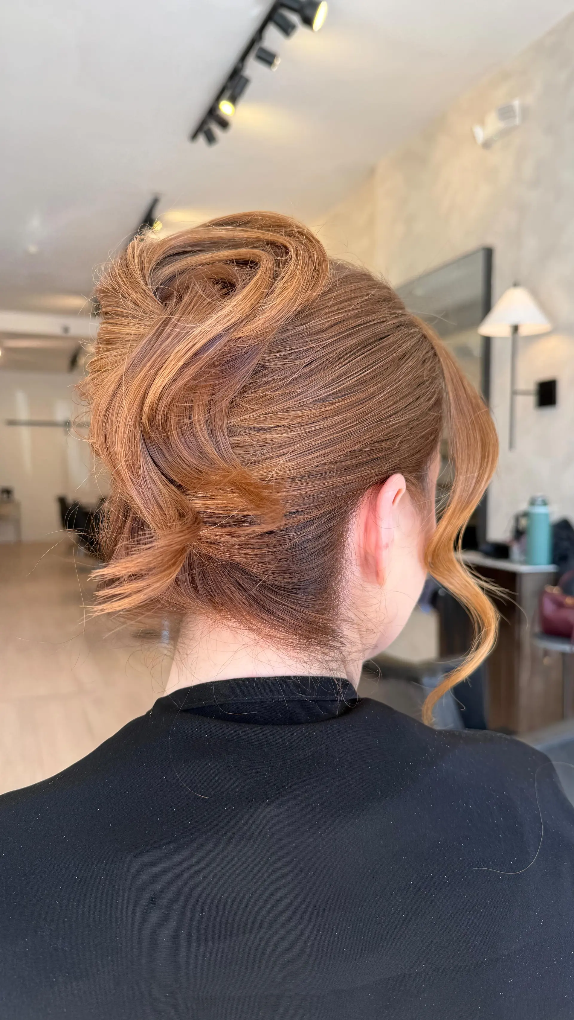 A modern textured twist updo with swept-up dimension and a soft face-framing tendril. 1