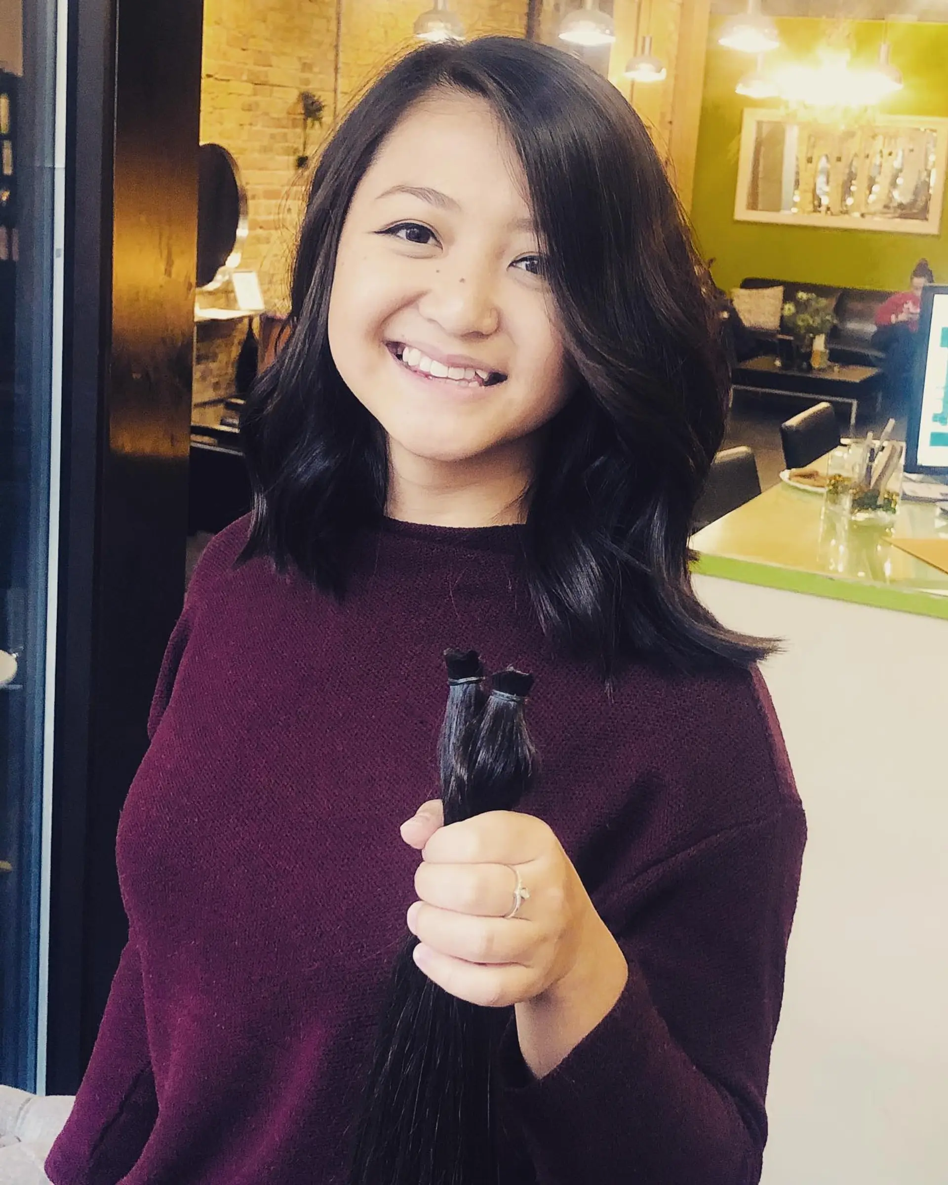 A textured shoulder-length long bob styled with relaxed, voluminous waves and a soft side part. 1