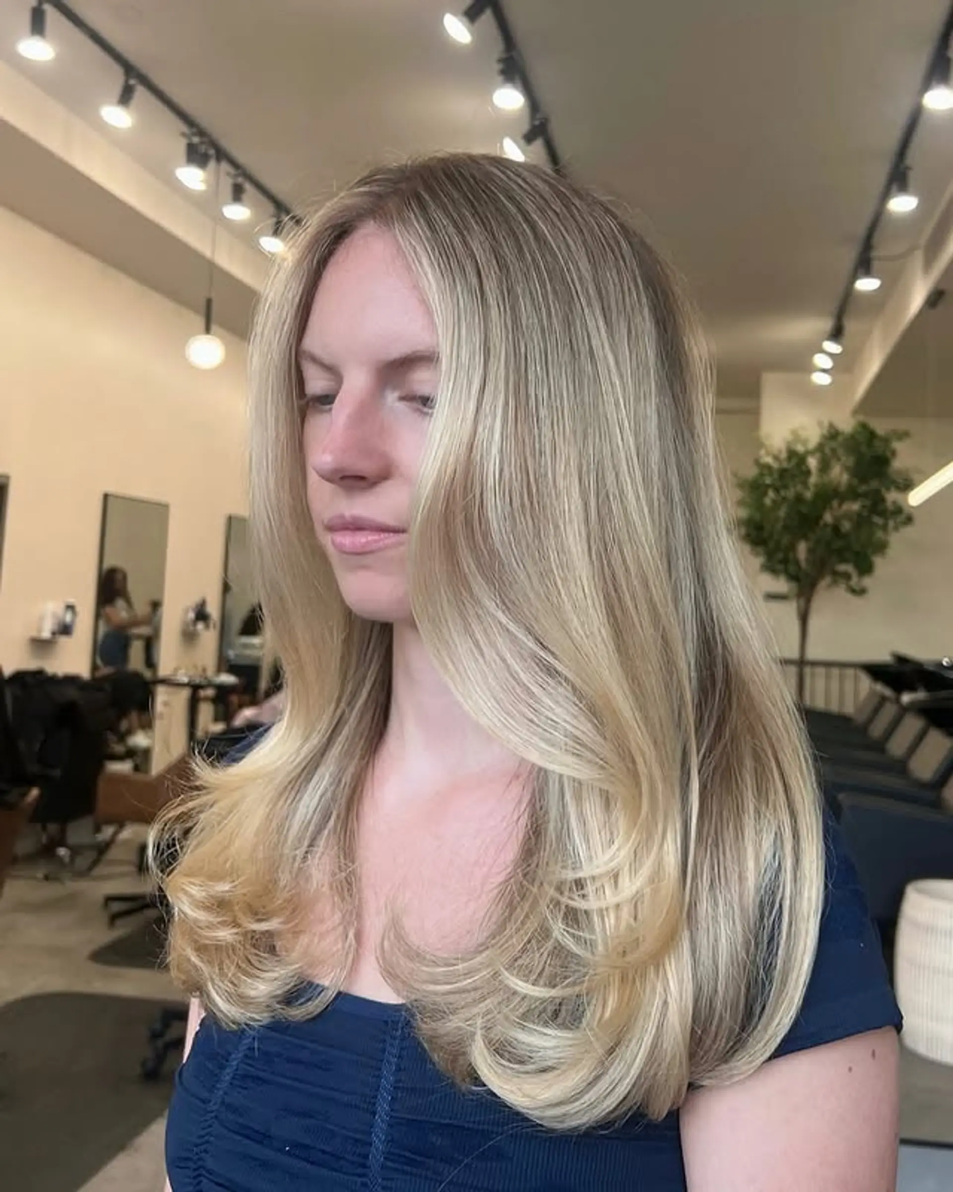 Long layered blonde hairstyle featuring a balayage and face-framing layers. 1