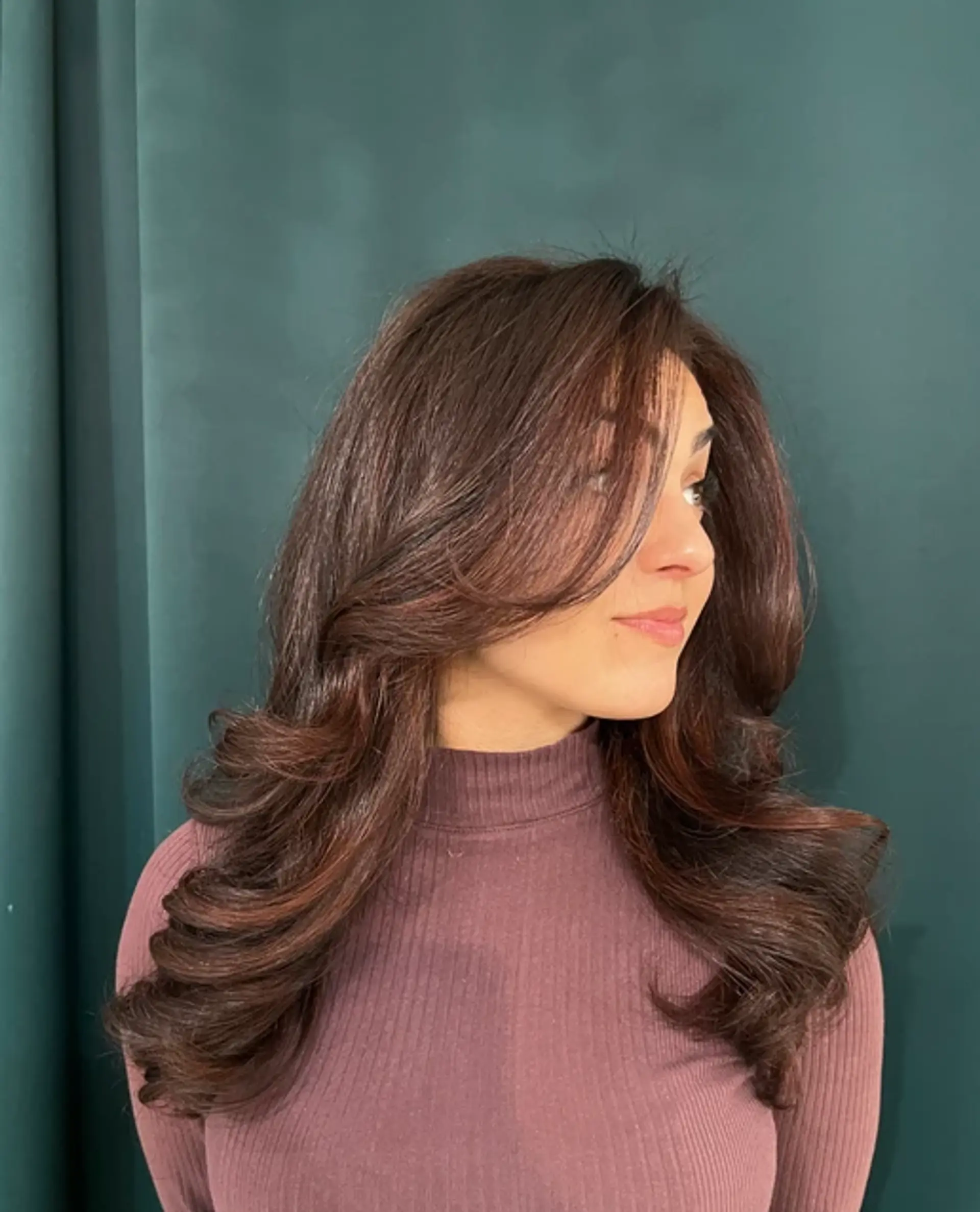 Rich dark brown, chestnut hues, long and straight, with voluminous soft waves cascading elegantly, featuring face-framing layers for an added elegance. 2
