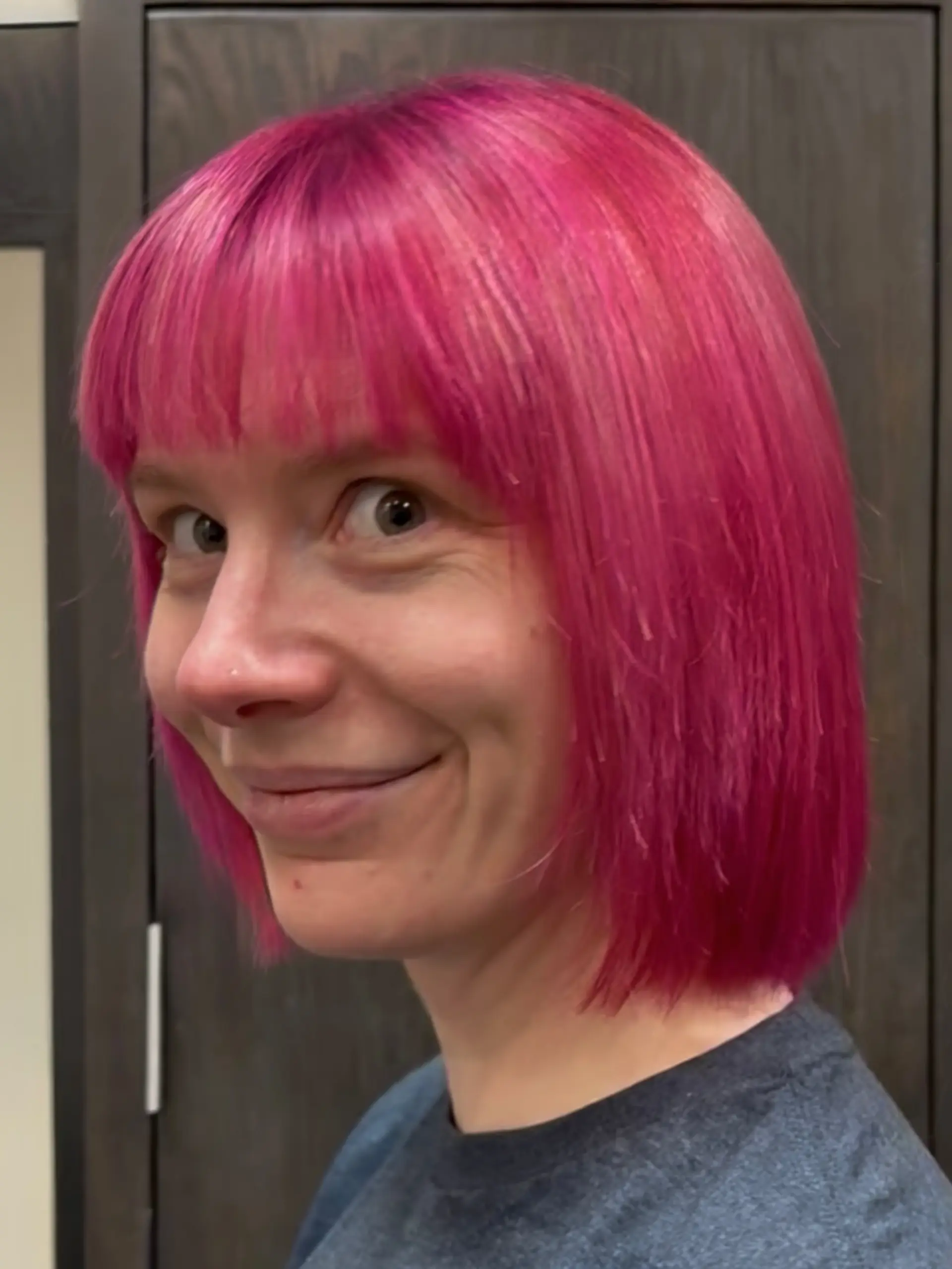 A vibrant magenta-pink chin-length bob haircut featuring straight front bangs. 1