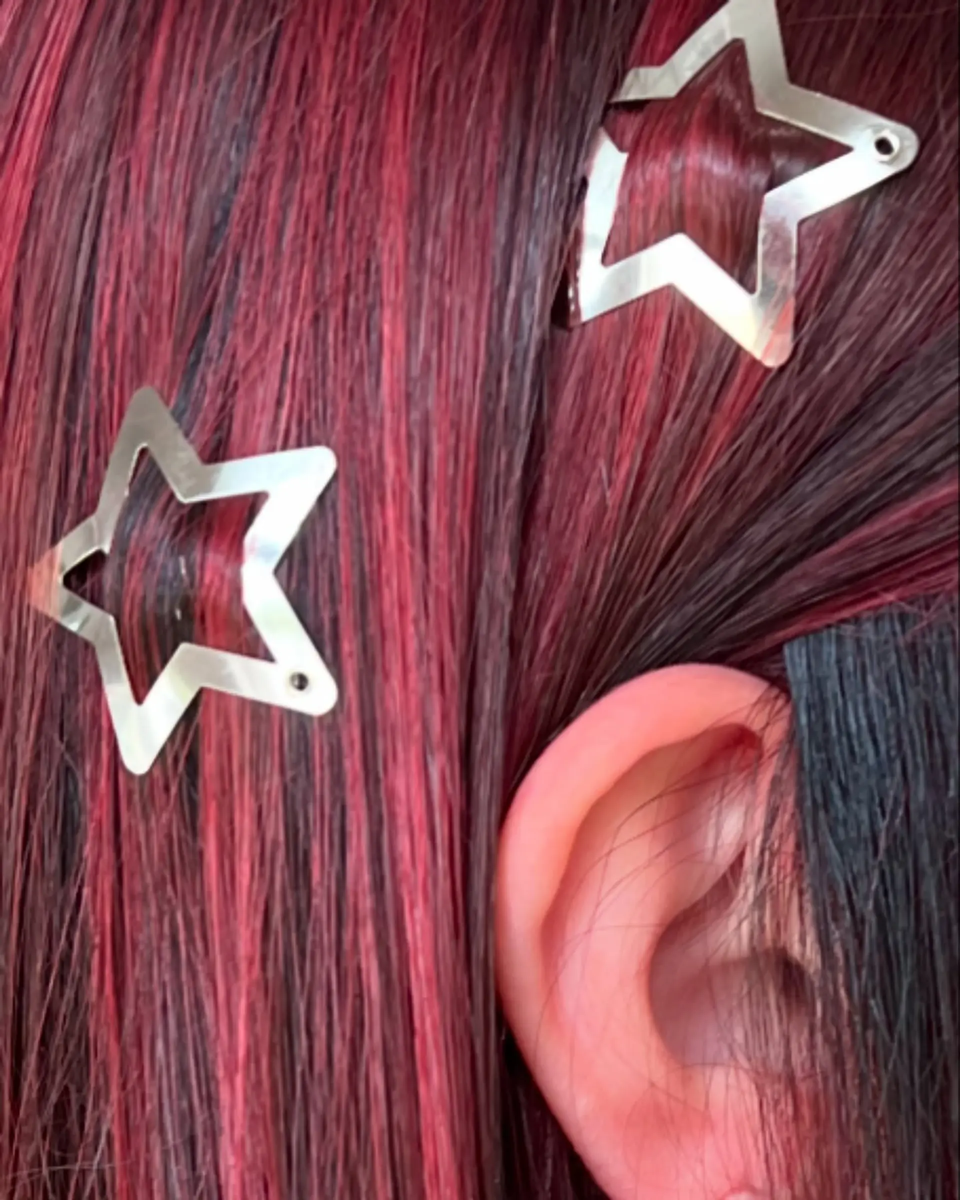 A sleek, long layered haircut adorned with vivid crimson red highlights meticulously placed over a darker base. The straight strands showcase the vibrant color contrast and natural movement, offering a dimensional and eye-catching look. 4