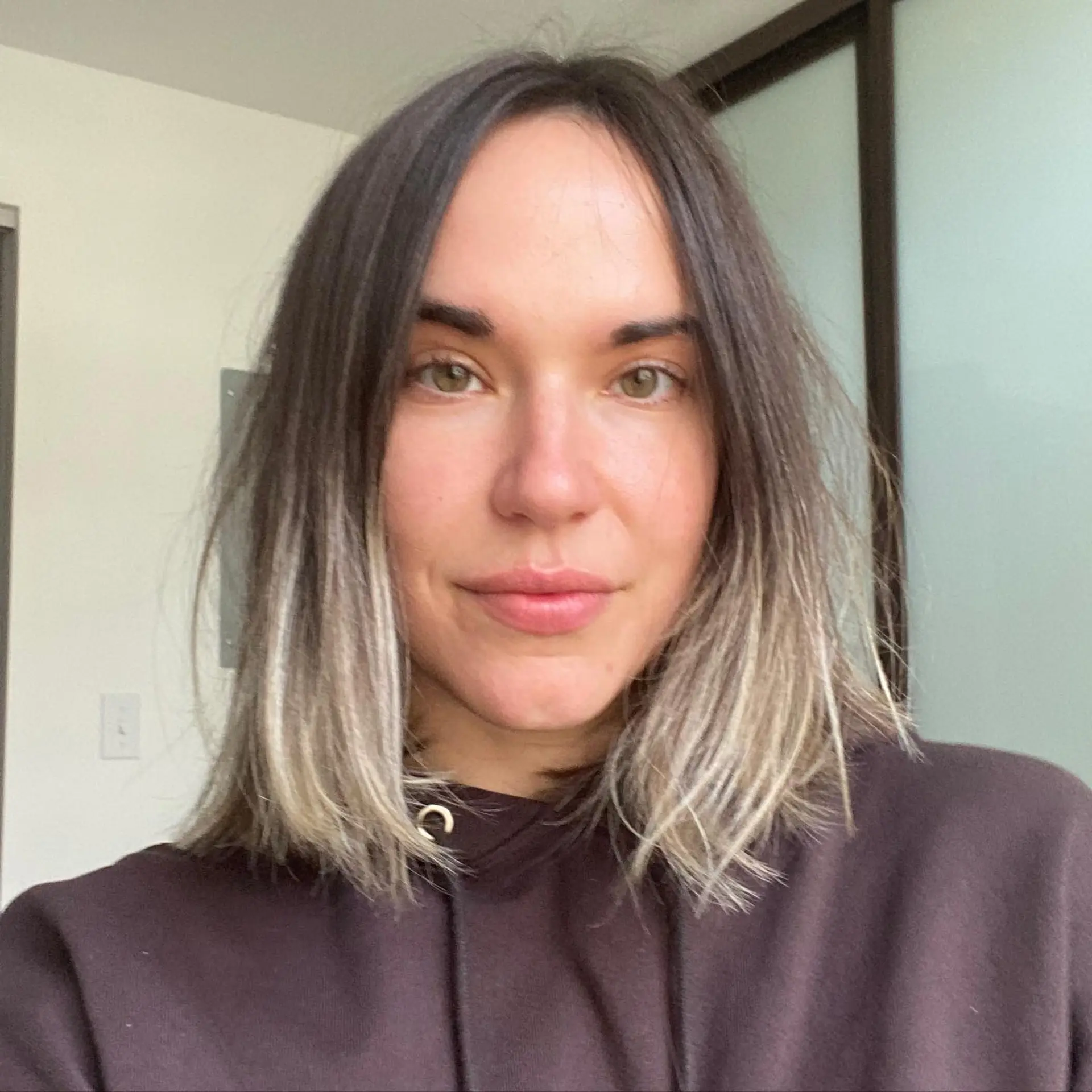 A collarbone-length blunt lob featuring a center part, textured ends, and a natural dark base transitioning into cool blonde ombre tips. 1