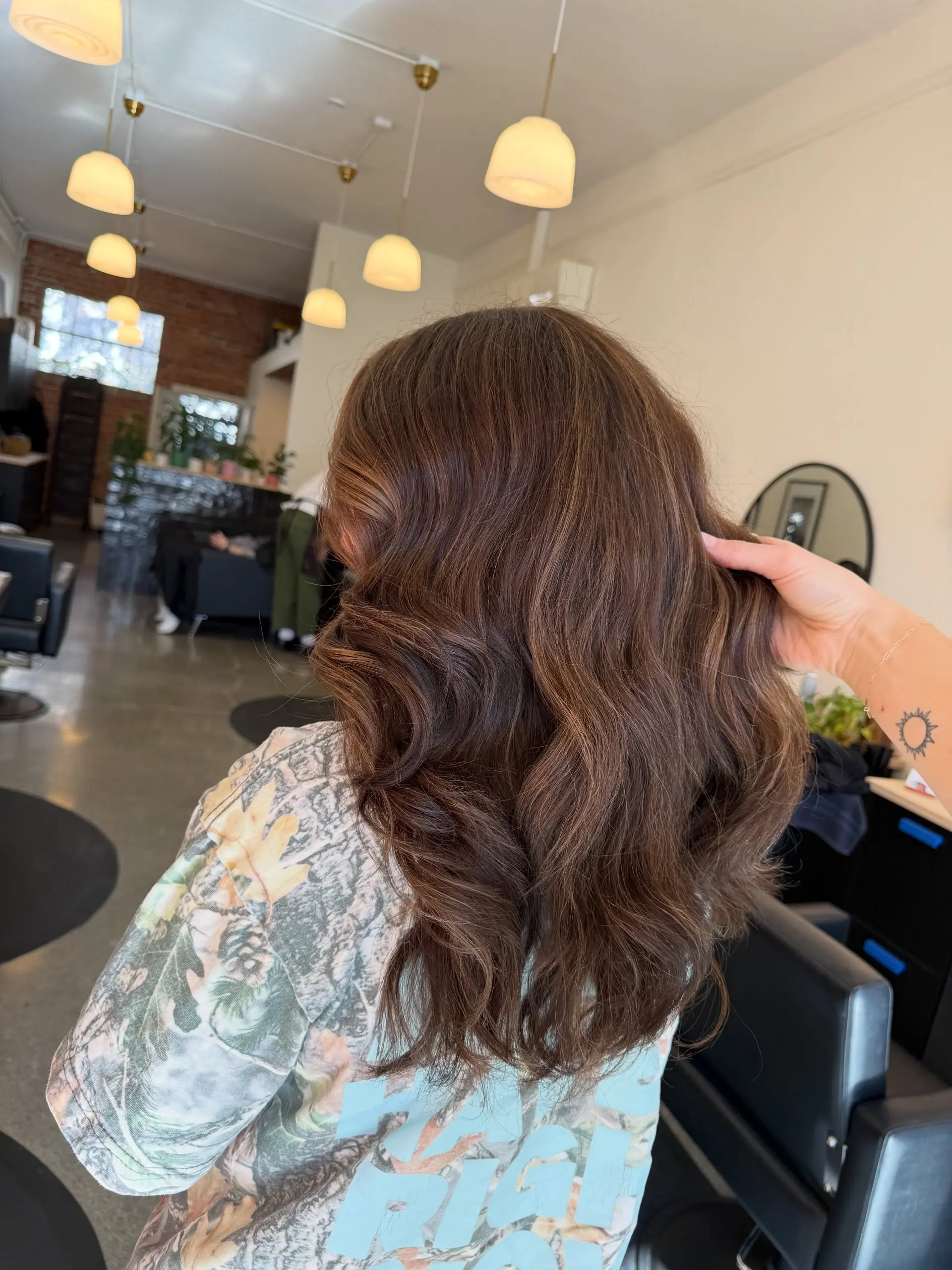 Rich chocolate brown hair styled into soft, flowing waves with subtle dimensional balayage highlights. 1