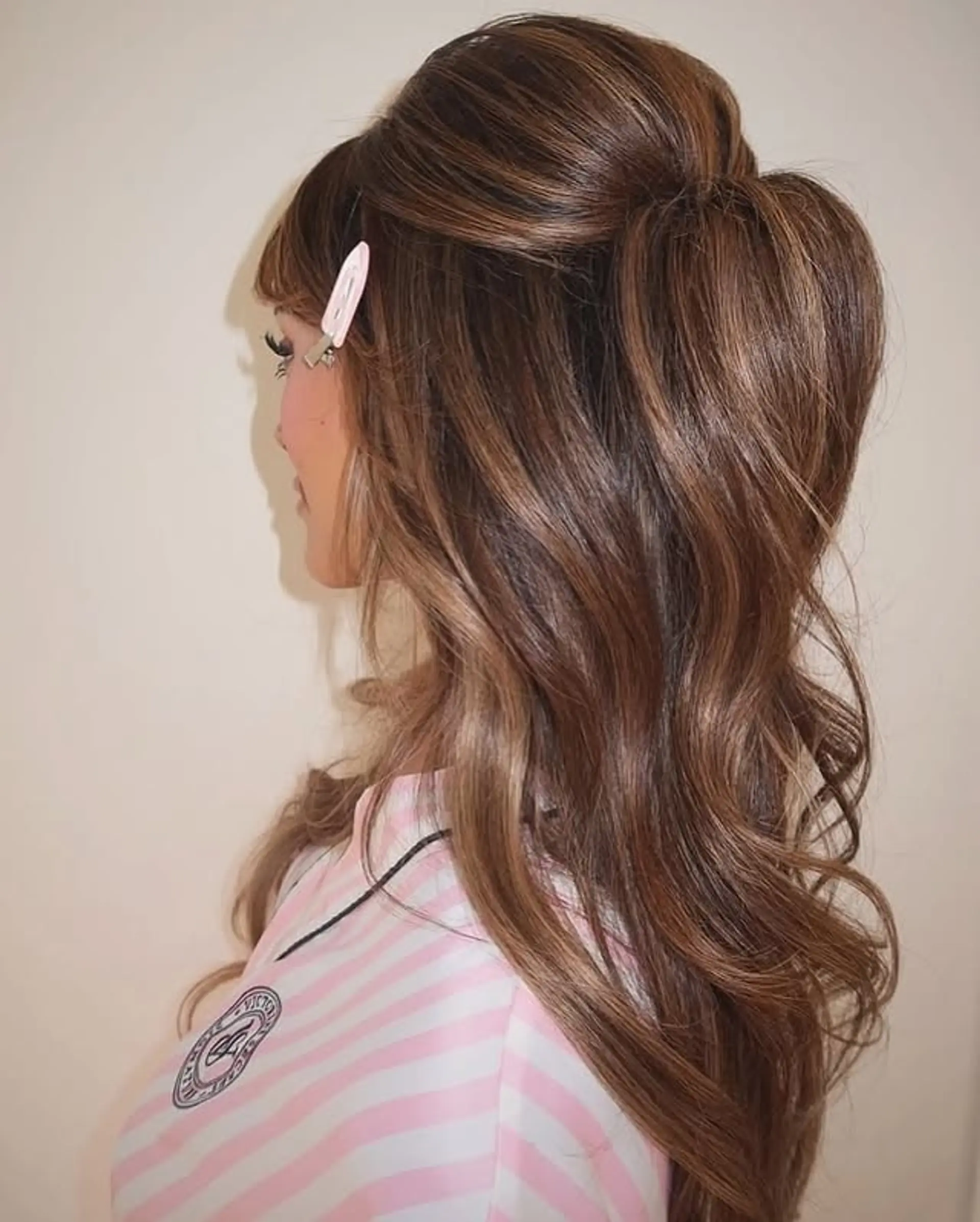 A voluminous half-up hairstyle with soft waves and a glamorous touch. 1
