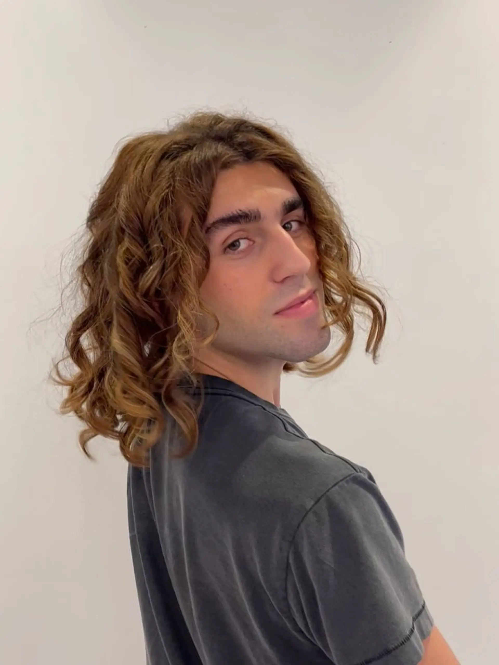 Medium-length curly cut shaped with defined spiral curls and soft volume. 1