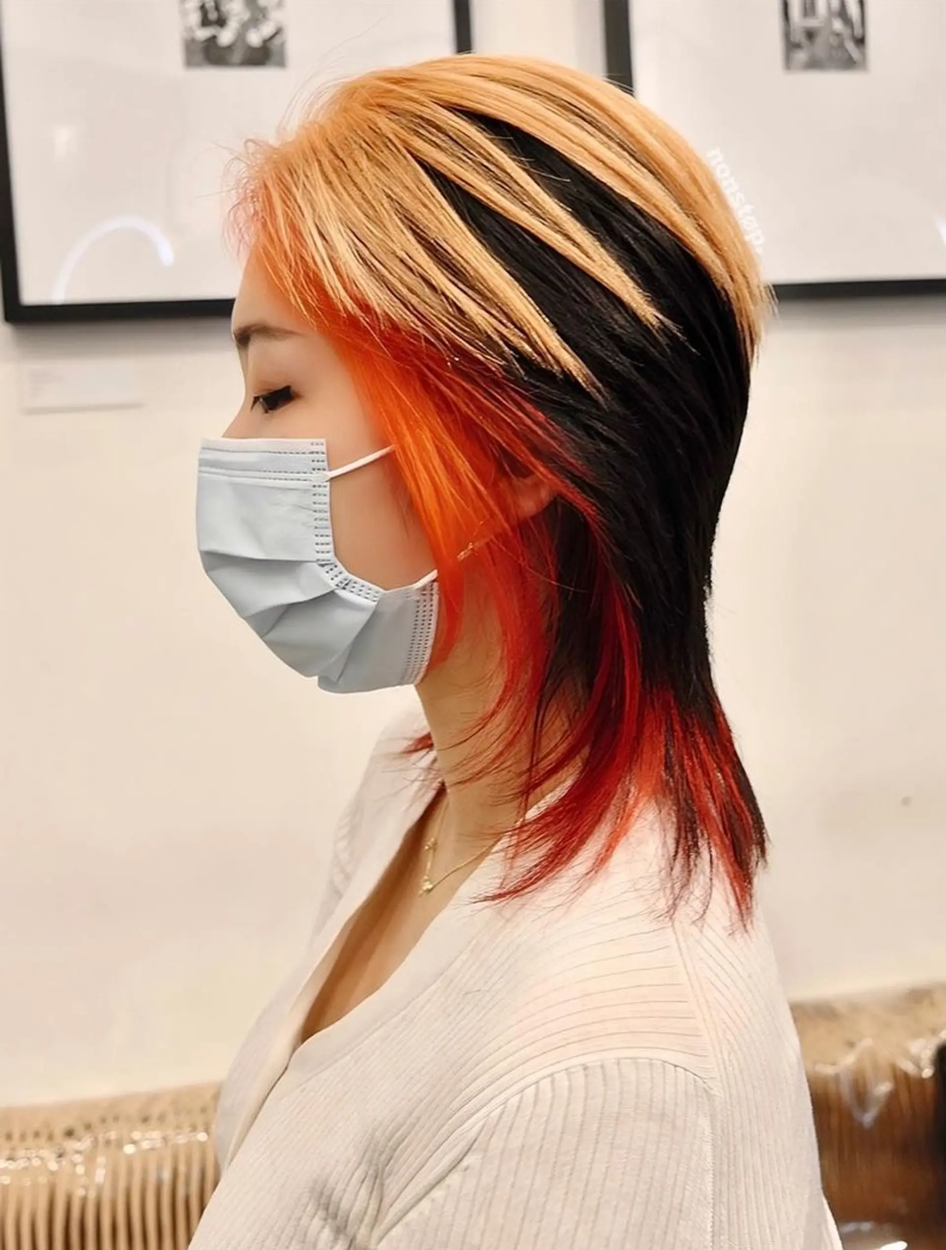 Medium-length, straight hair in a layered cut with a blonde and orange ombre on the outer layer and a black underlayer. 1