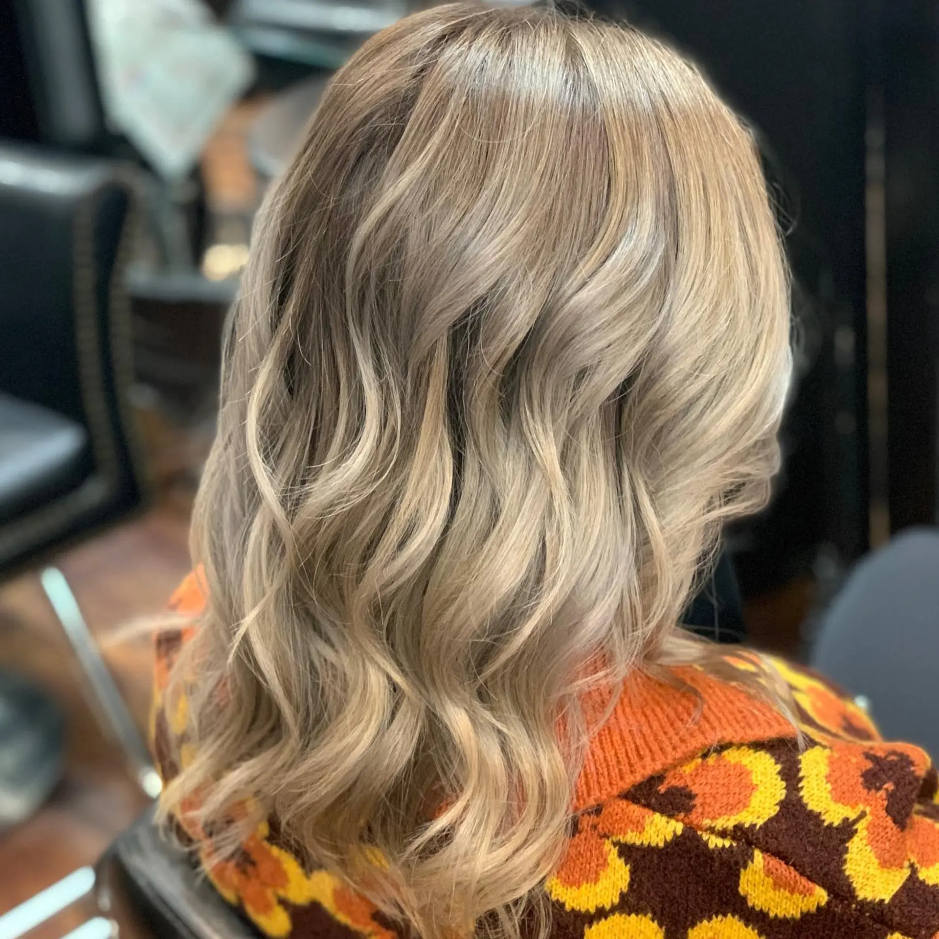 Medium-length ash beige blonde balayage styled in loose, textured waves. 1