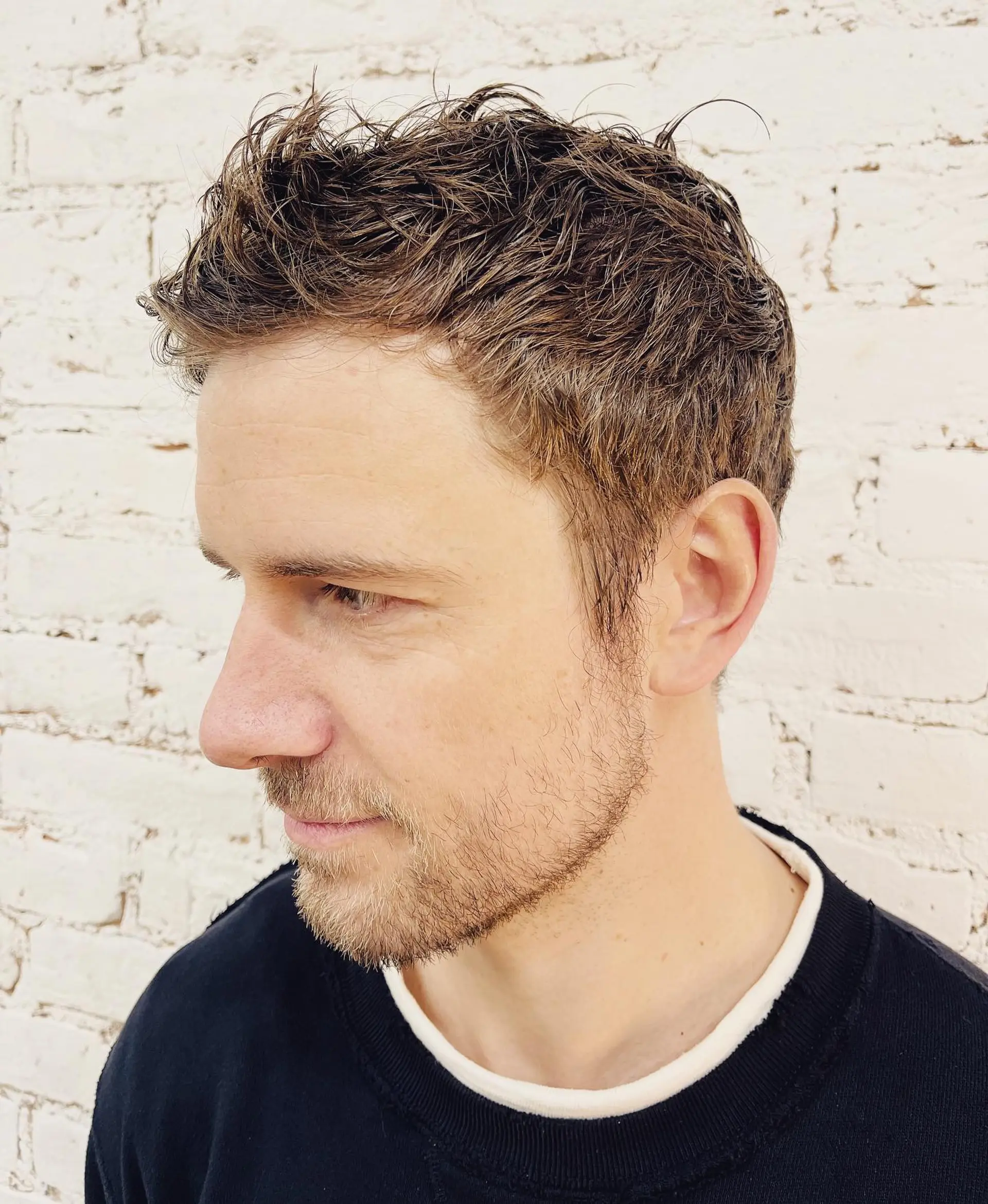 A textured short men's haircut styled with piecey separation on top and neatly tapered sides. 1
