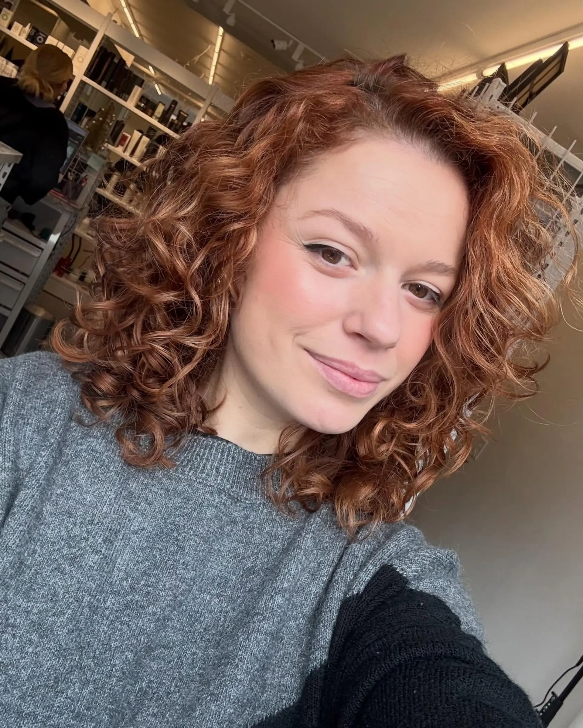 Voluminous shoulder-length auburn curls with defined texture and warm copper tones. 1