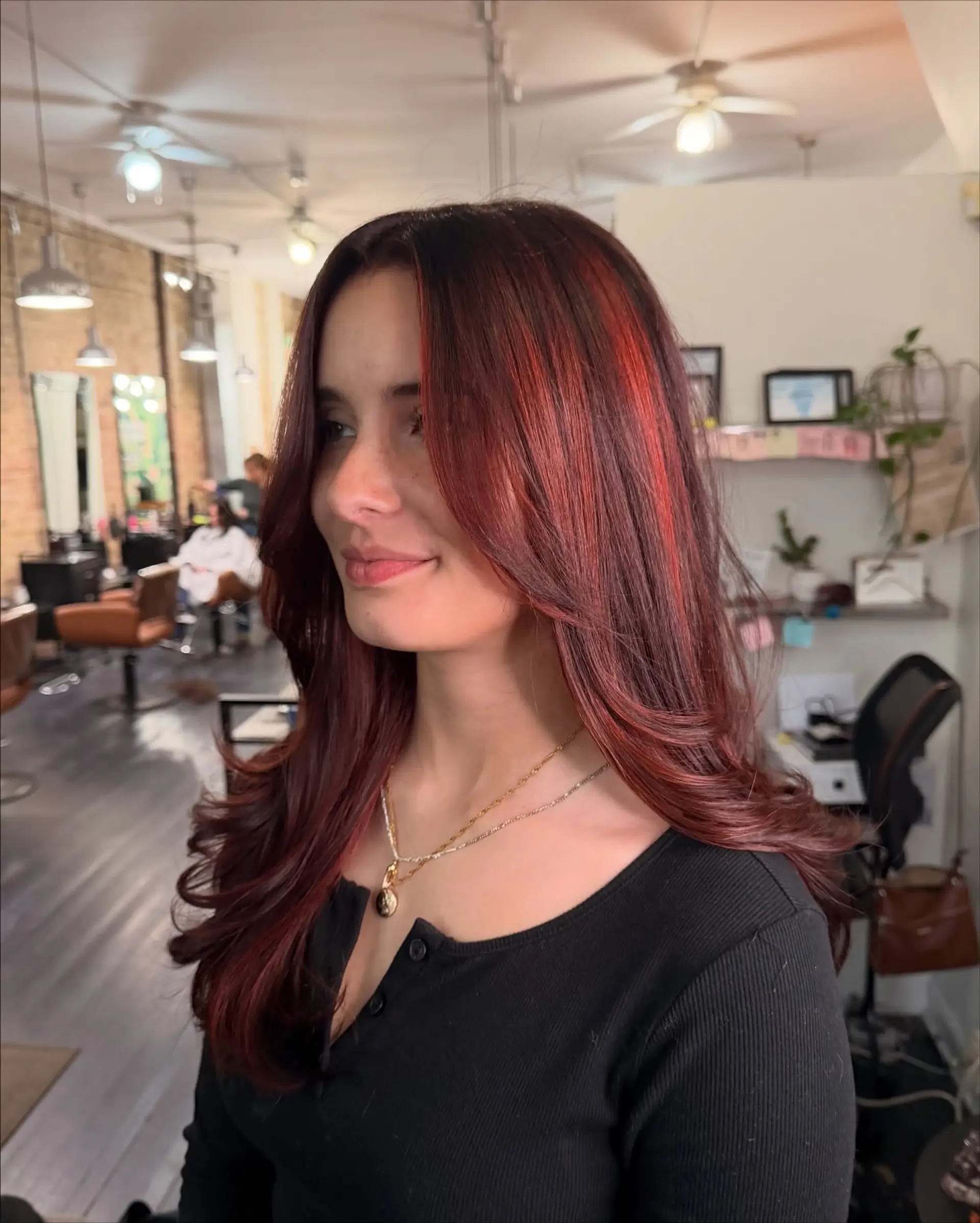 Long layered haircut with a face-framing blowout, rich deep auburn base, and vibrant red highlight ribbons. 1