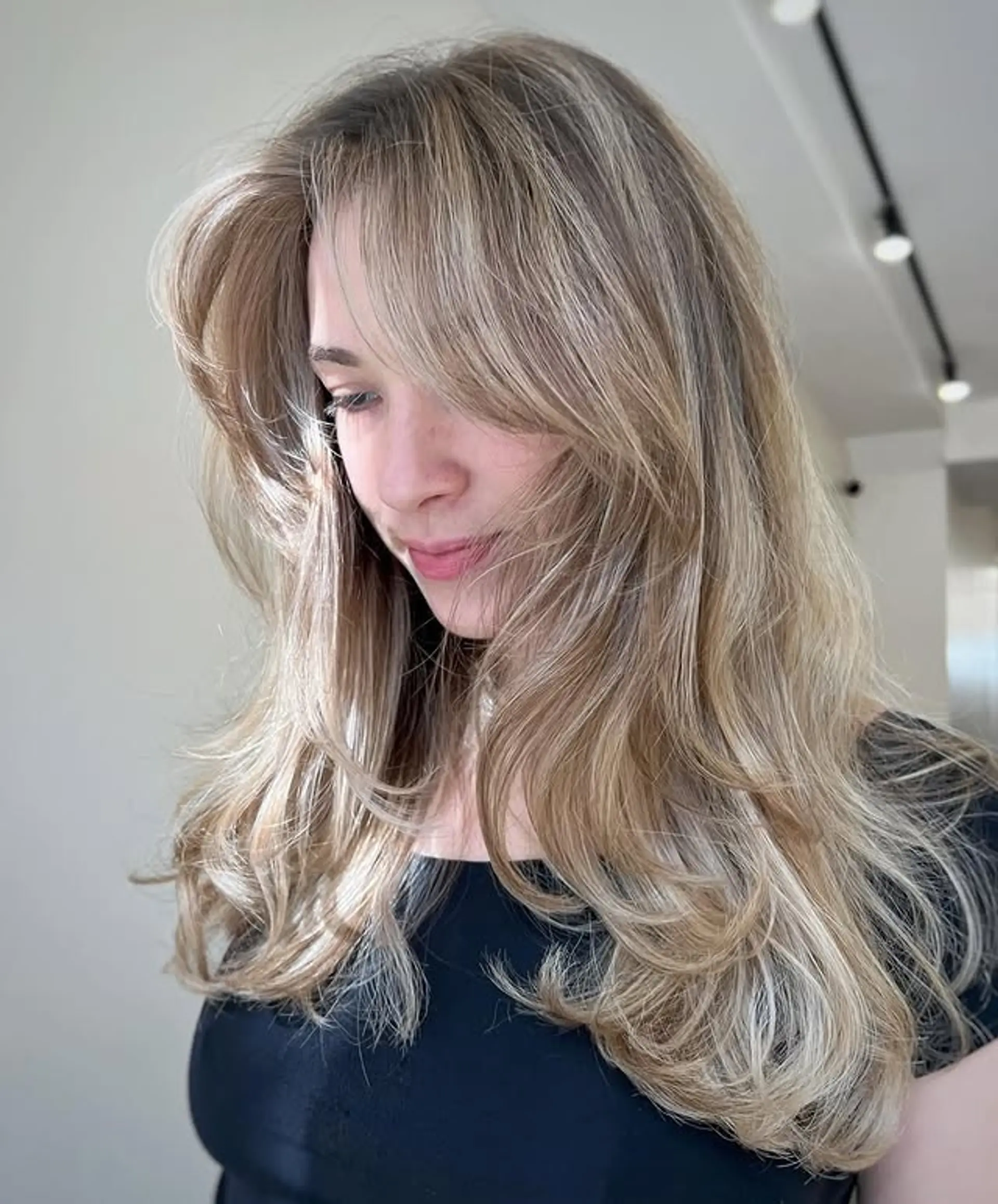 A long, wavy, layered cut with face-framing layers and trendy curtain bangs. 1