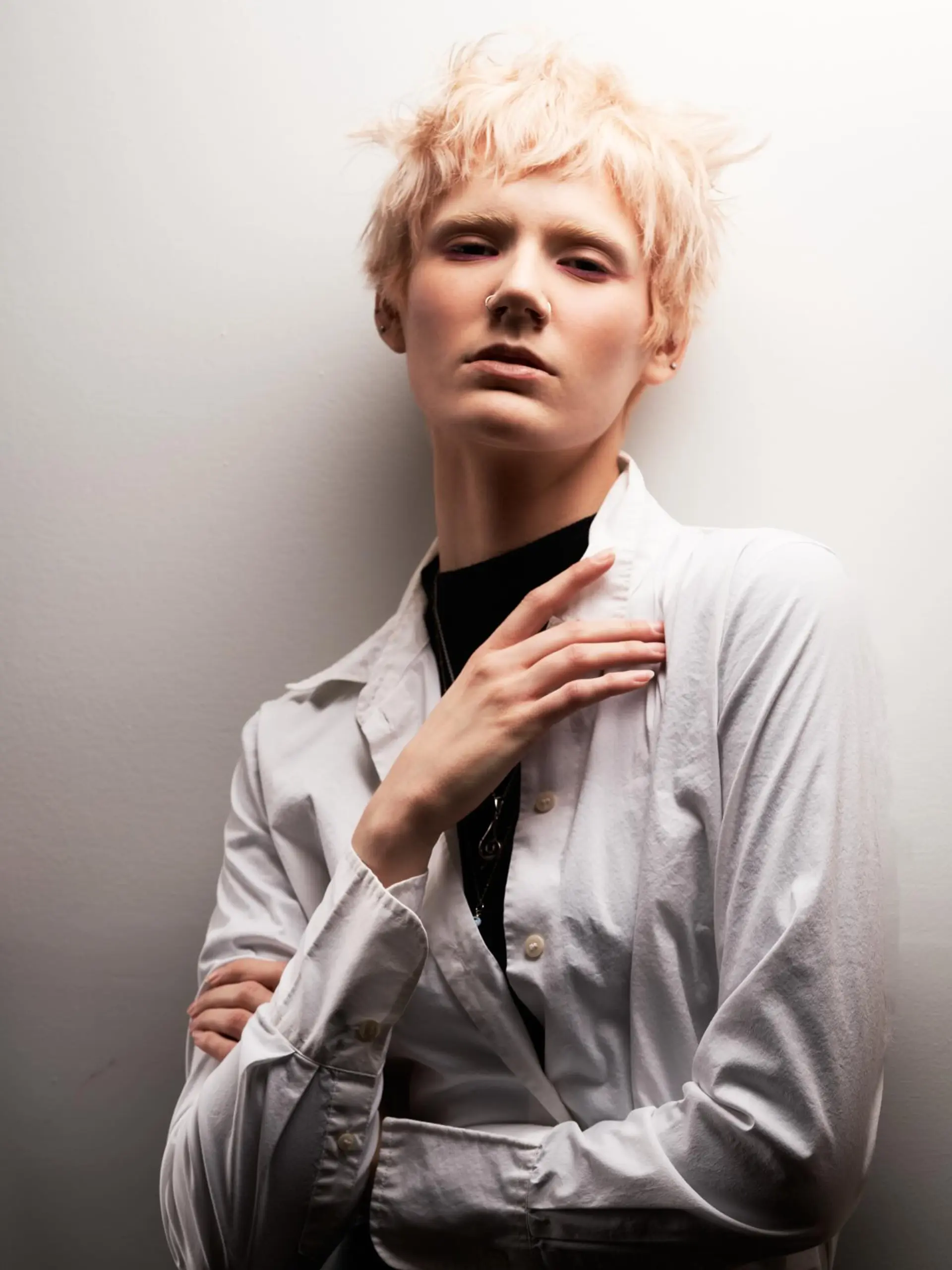 A textured short pixie cut styled with tousled layers and soft, choppy fringe in a pale champagne blonde. 1