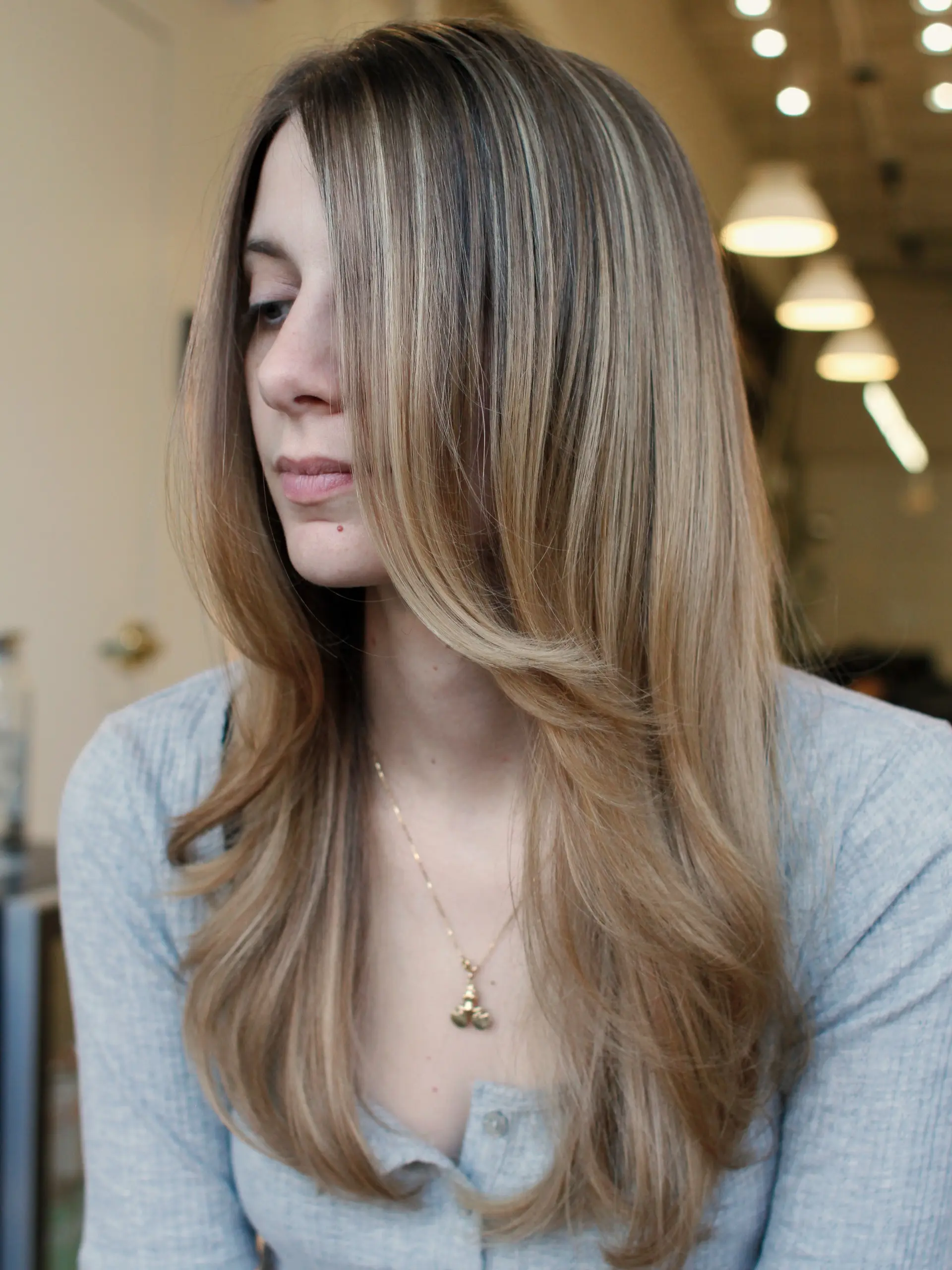 Long beige blonde hair with fine dimensional highlights and sweeping face-framing layers styled in a soft blowout. 1
