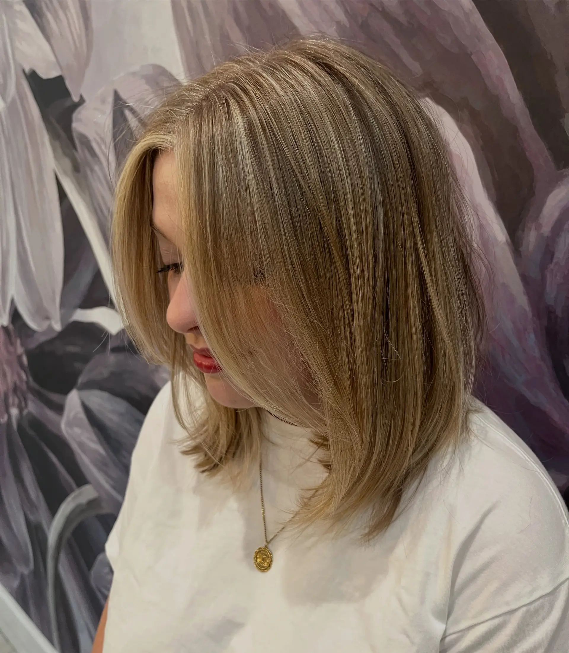 A straight, shoulder-skimming lob featuring fine multi-dimensional blonde highlights and soft face-framing layers. 1