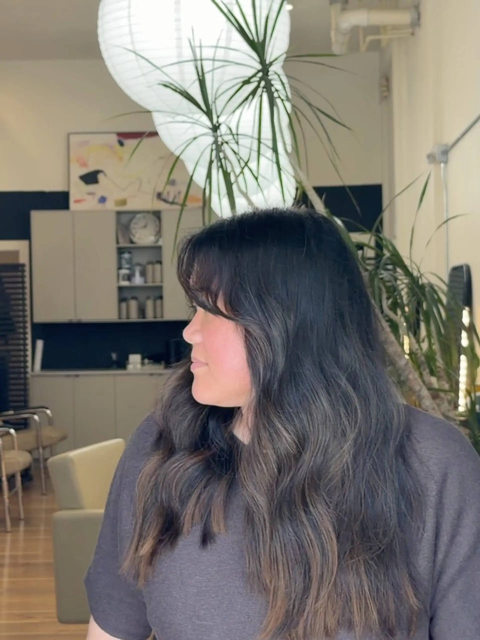Long, flowing dark brunette hair styled with soft, loose waves and wispy front bangs. 1