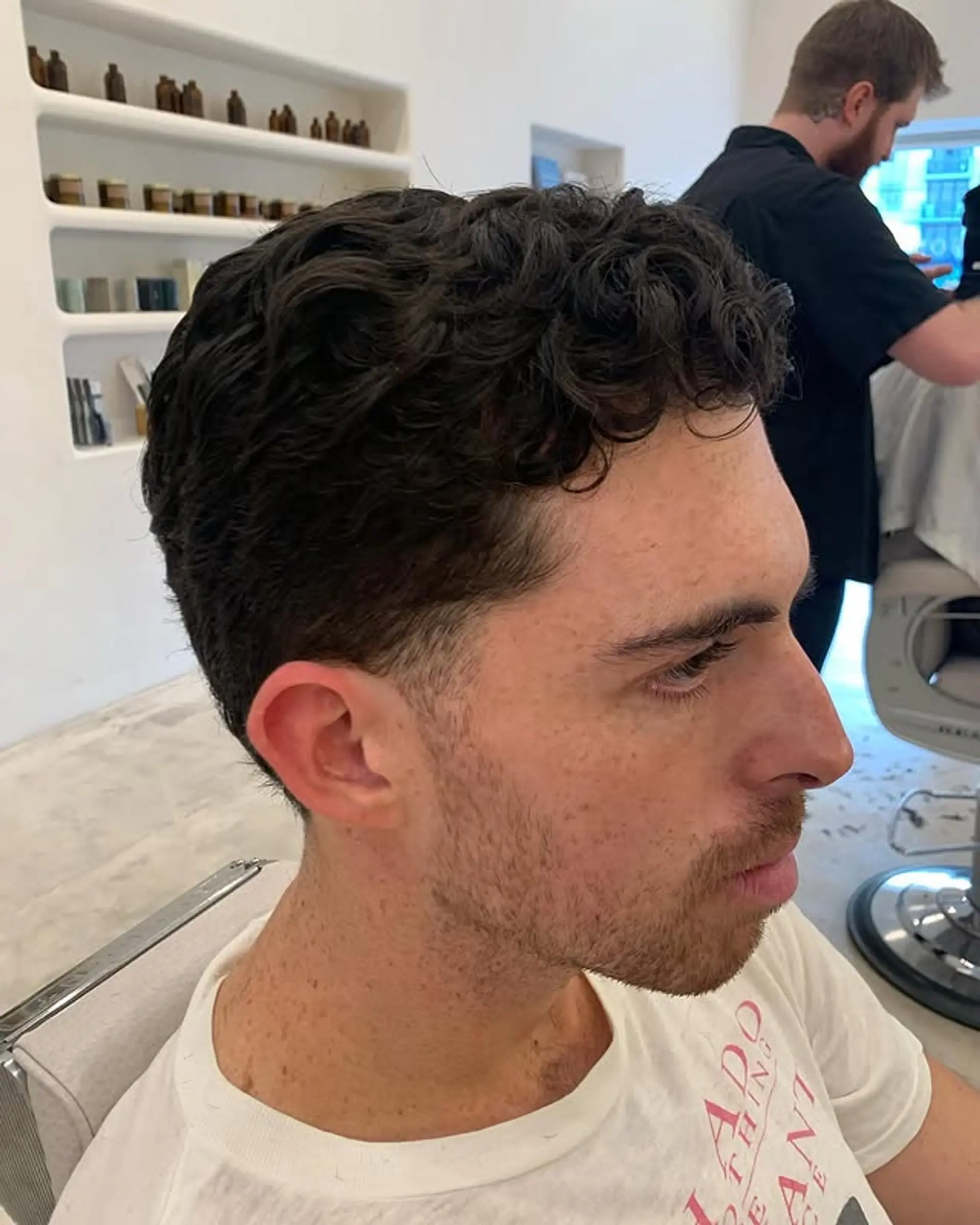 A short, textured curly crop with tapered sides. 1