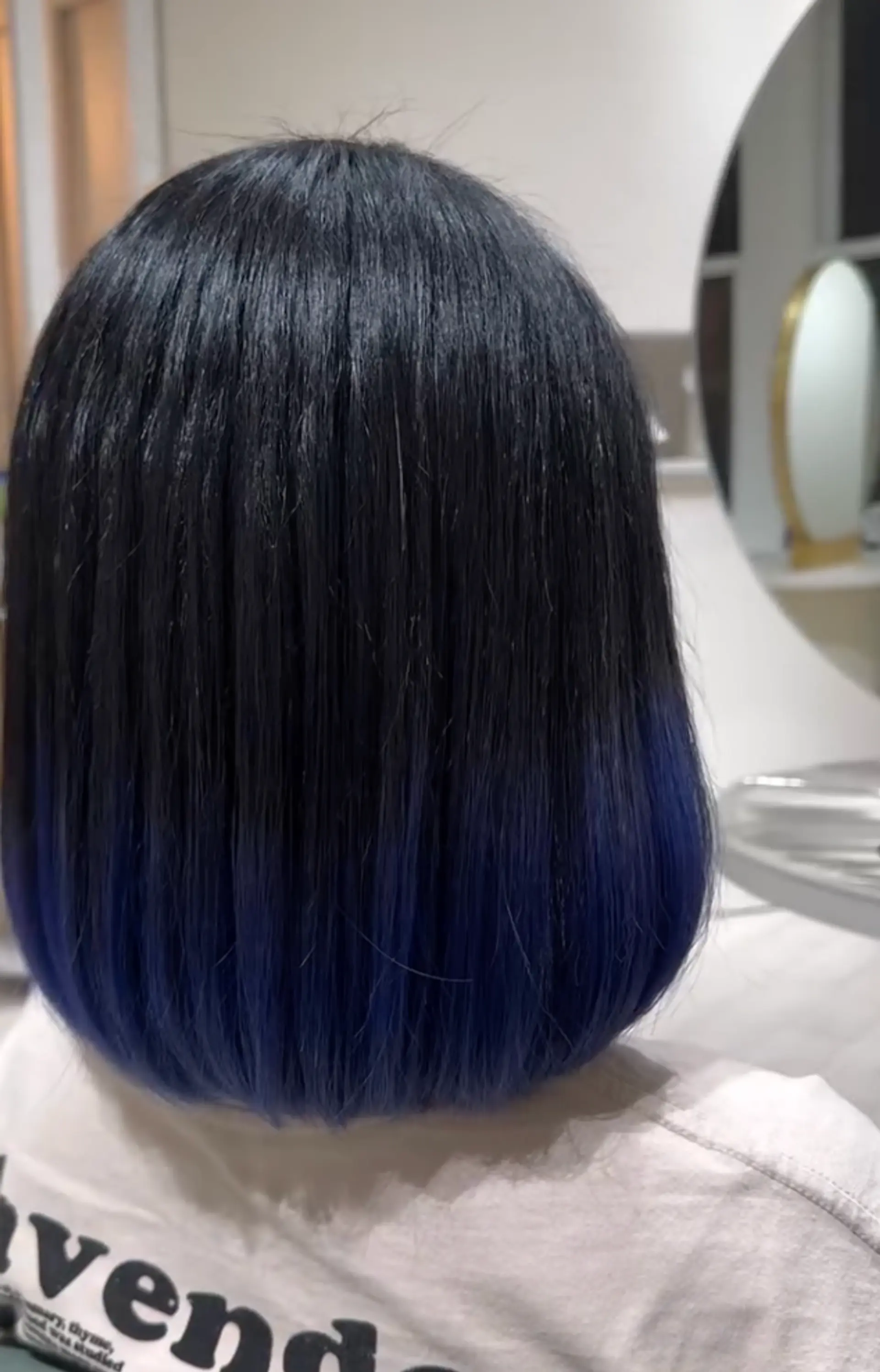 A sleek, medium-length hairstyle with a black to blue violet ombre effect and a blunt cut. 2