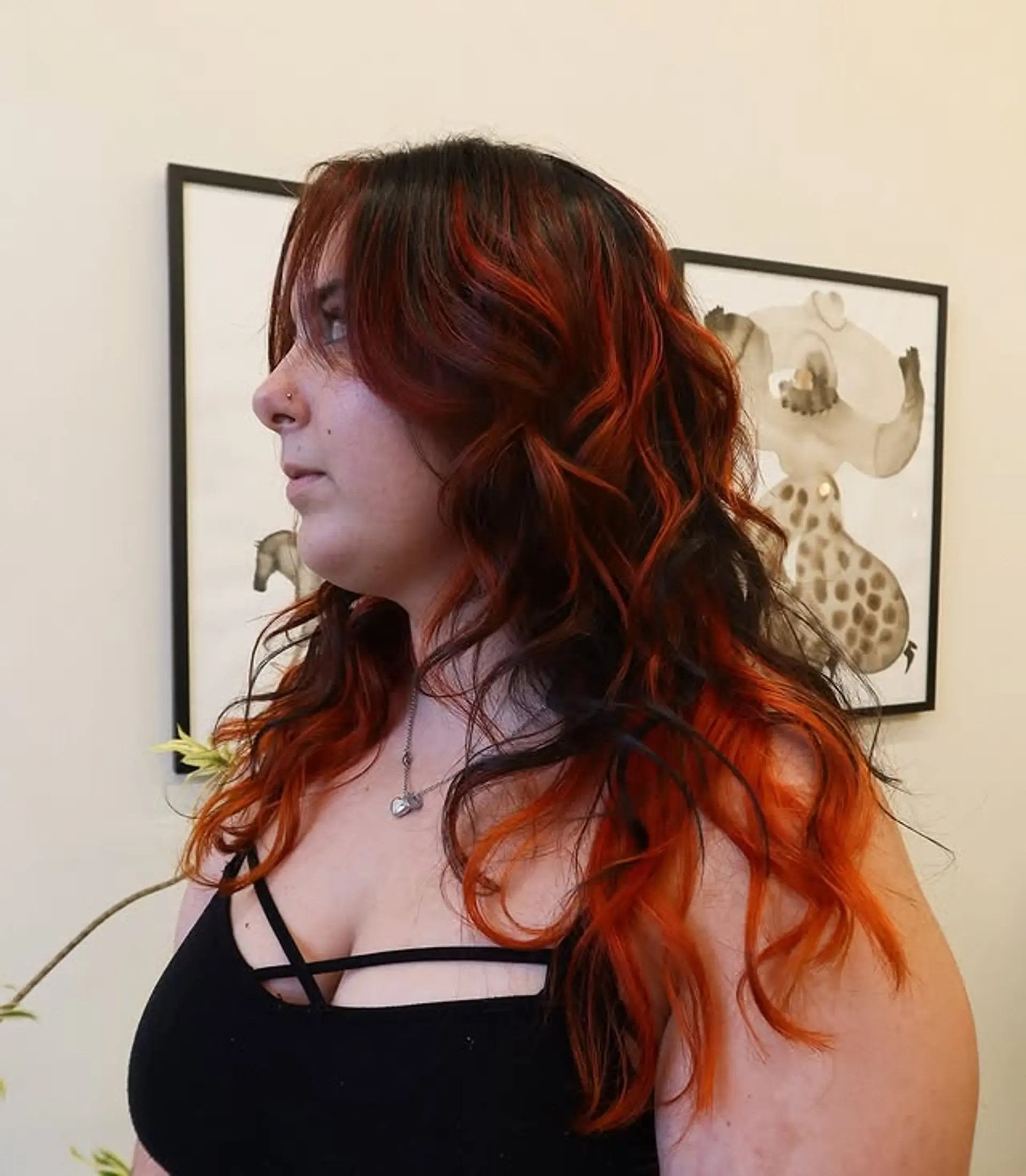 This hairstyle features copper highlights on a dark base, with face-framing layers and a wavy texture. 1