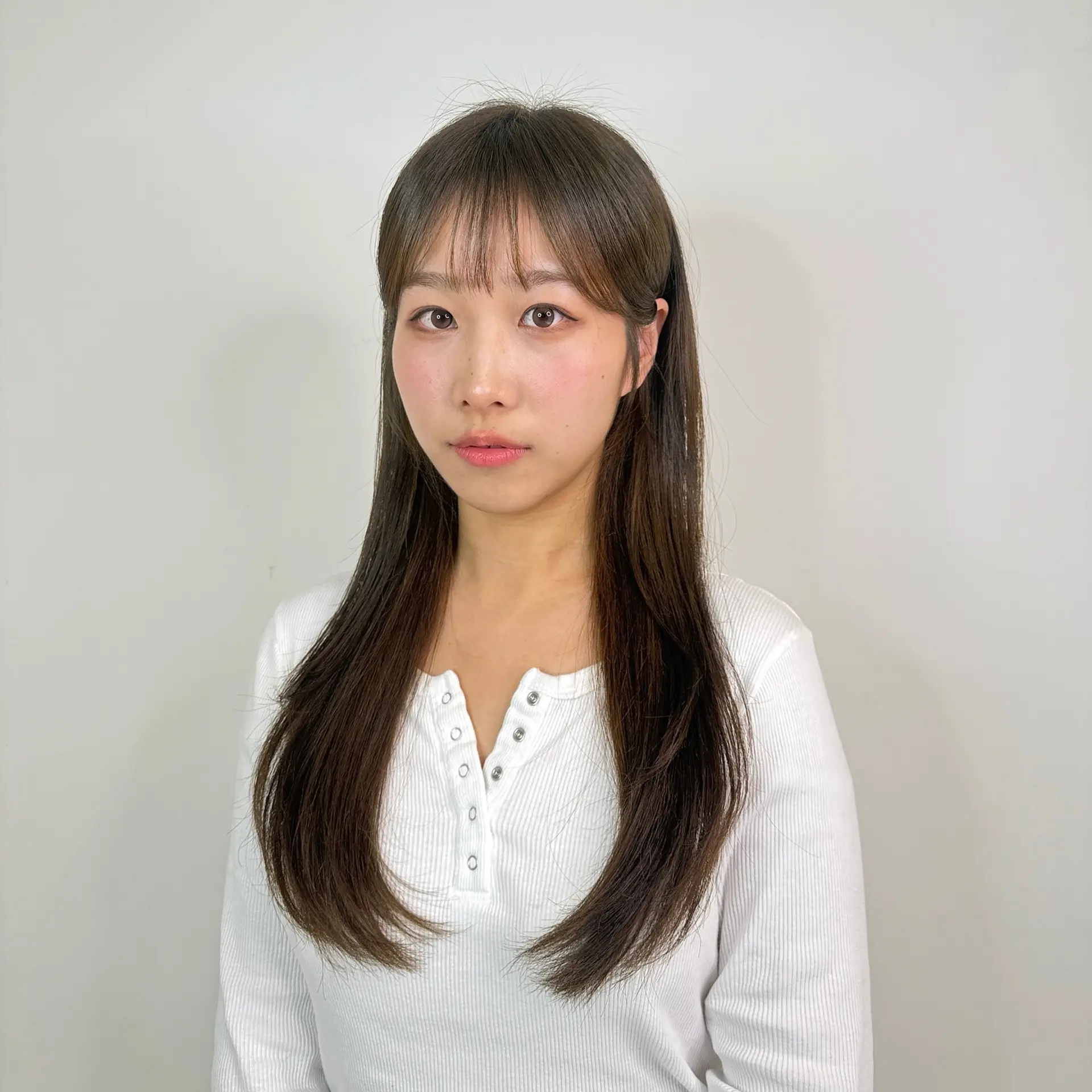 Long straight layered cut with light, wispy see-through bangs in a cool matte brown shade. 1