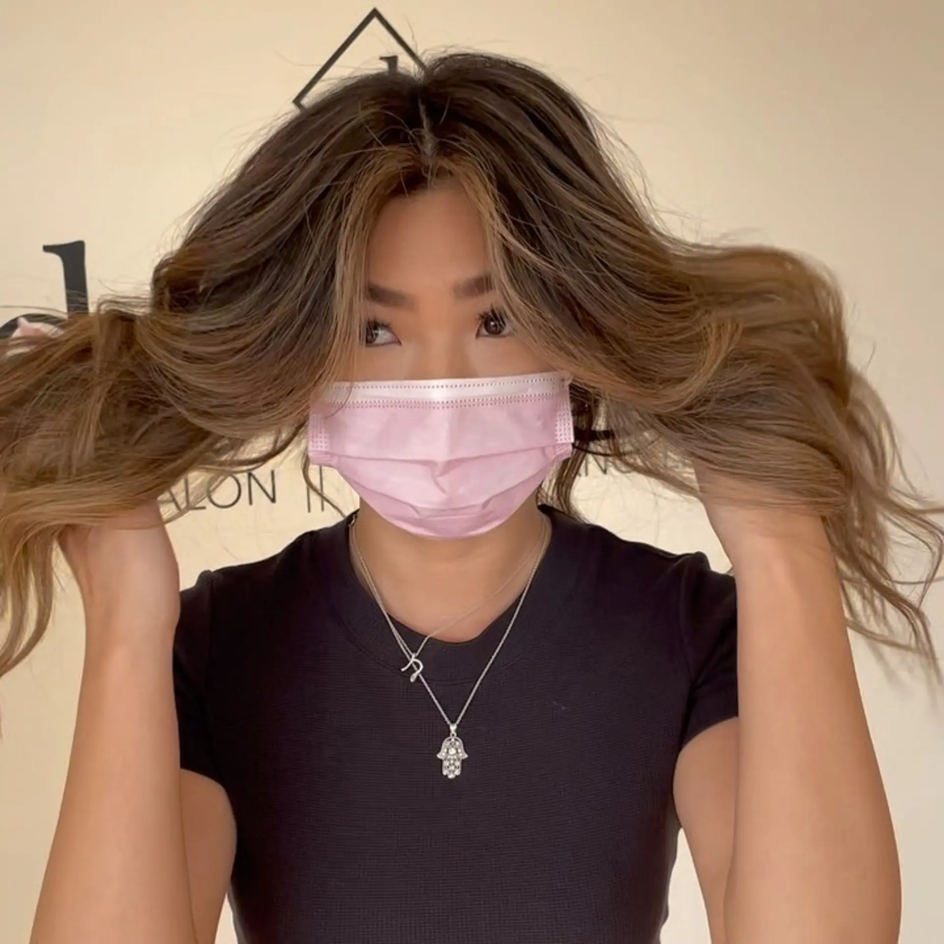 Dimensional brunette hair featuring soft face-framing money piece highlights styled in voluminous waves. 1