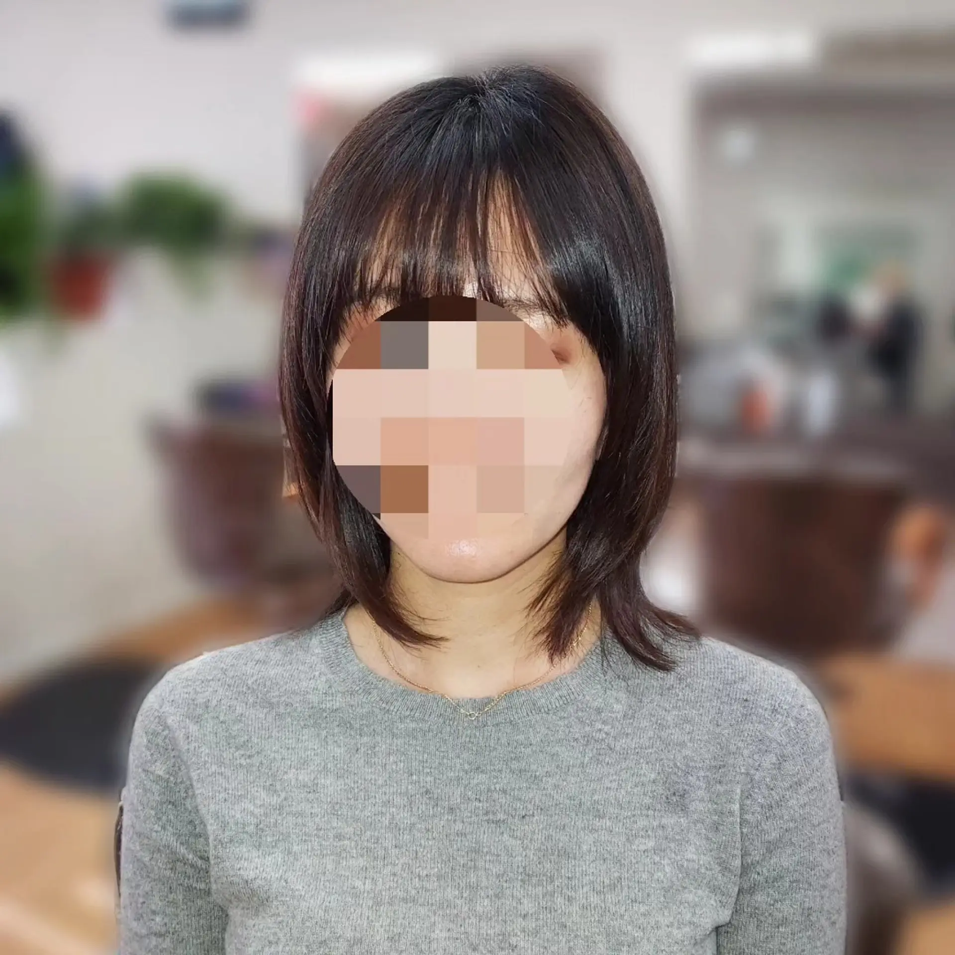 A textured shoulder-length haircut with face-framing layers and light, wispy bangs. 1