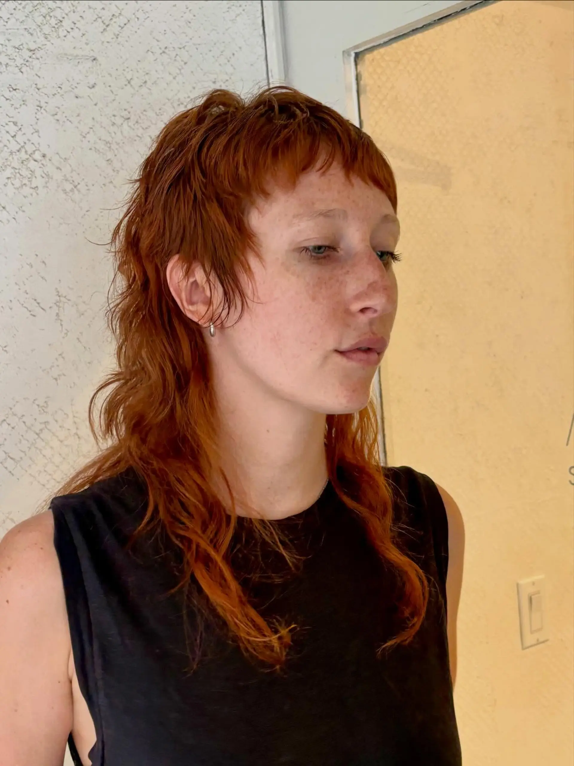A bold copper shag mullet styled with textured micro bangs and piecey layers cascading over the shoulders. 1