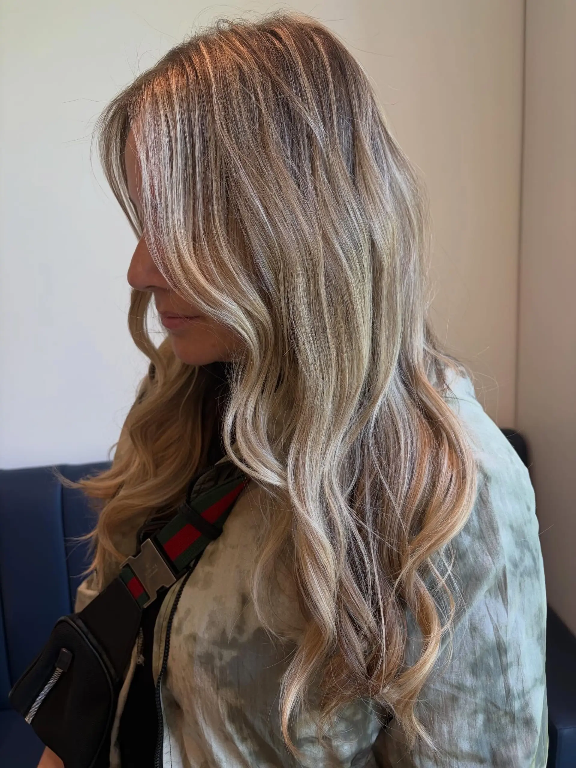 Long dimensional blonde hair styled in soft, cascading waves with delicate face-framing layers. 1
