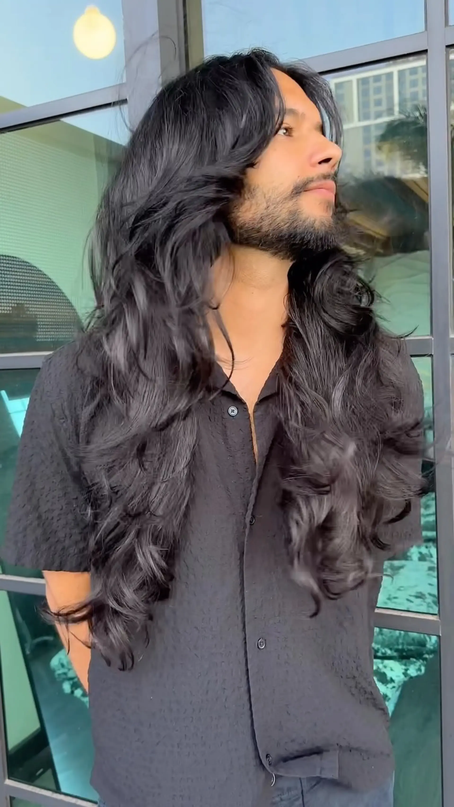 Long, thick black hair shaped with cascading layers and styled with voluminous, bouncy waves. 1